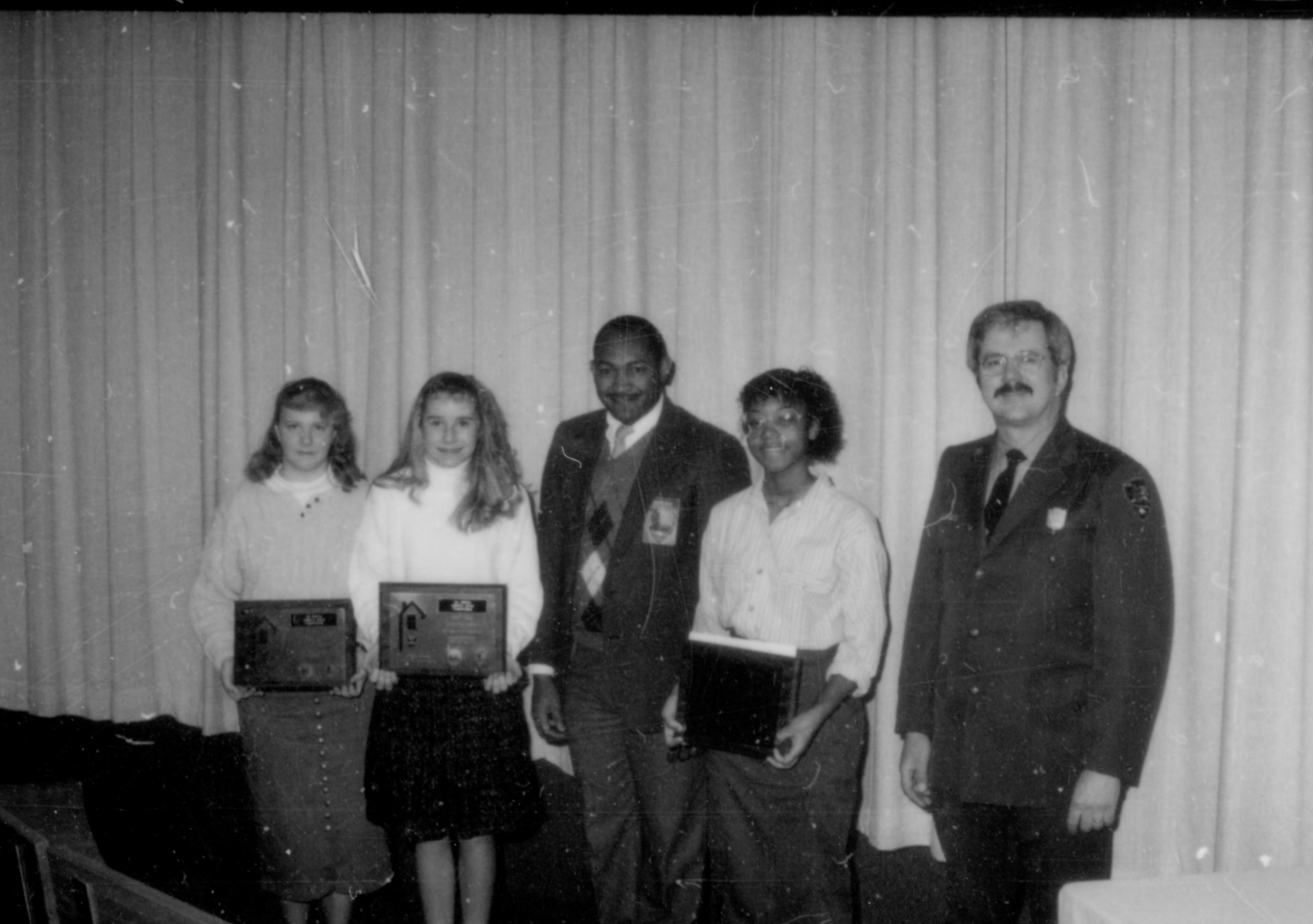 Three young ladies (with awards) and two men in front of curtain. Lincoln Home NHS- Lincoln's Birthday 1988, 26 birthday, Lincoln, award