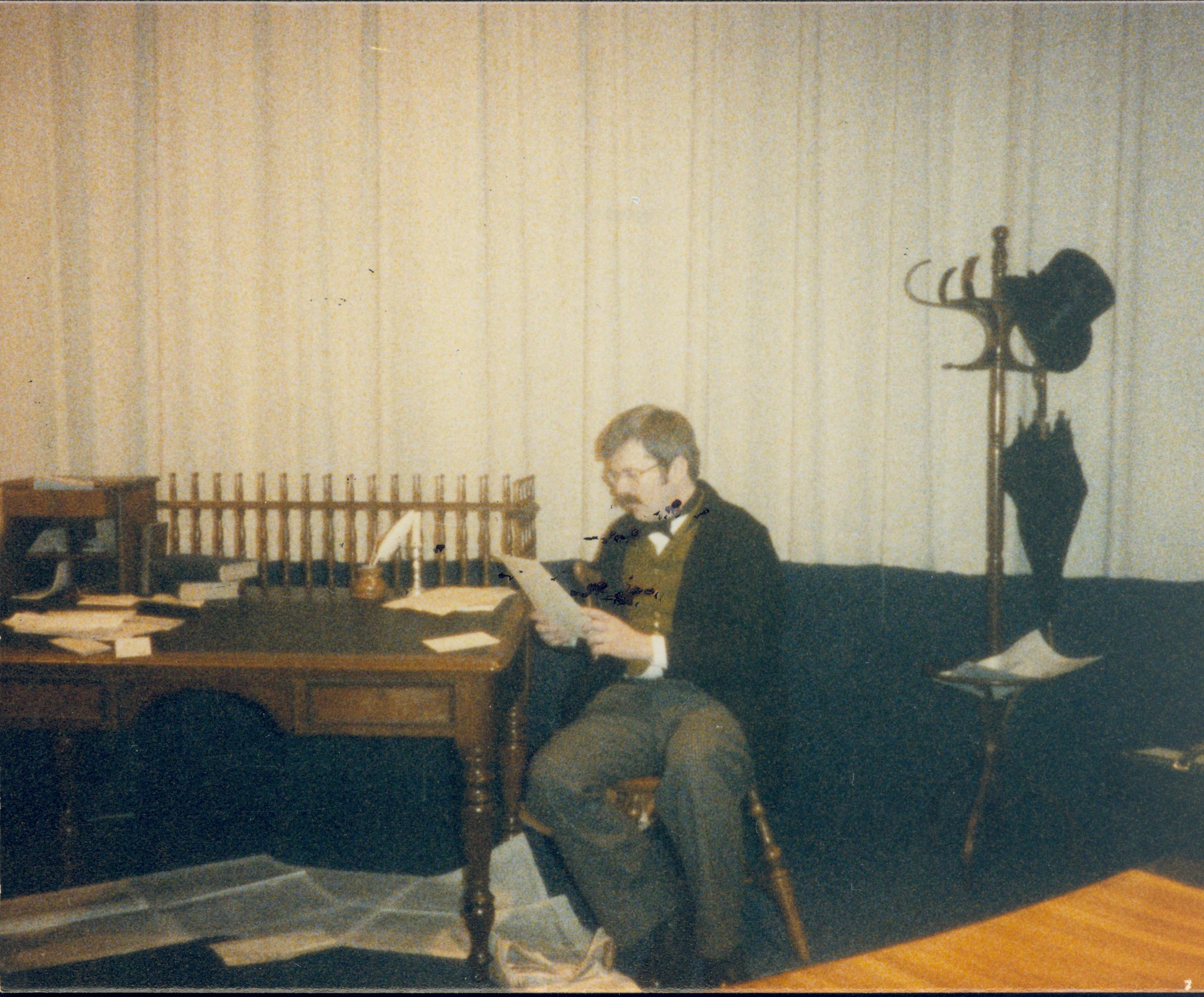 Man in period dress seated reading document. Lincoln Home NHS- Lincoln's Birthday birthday, Lincoln, play