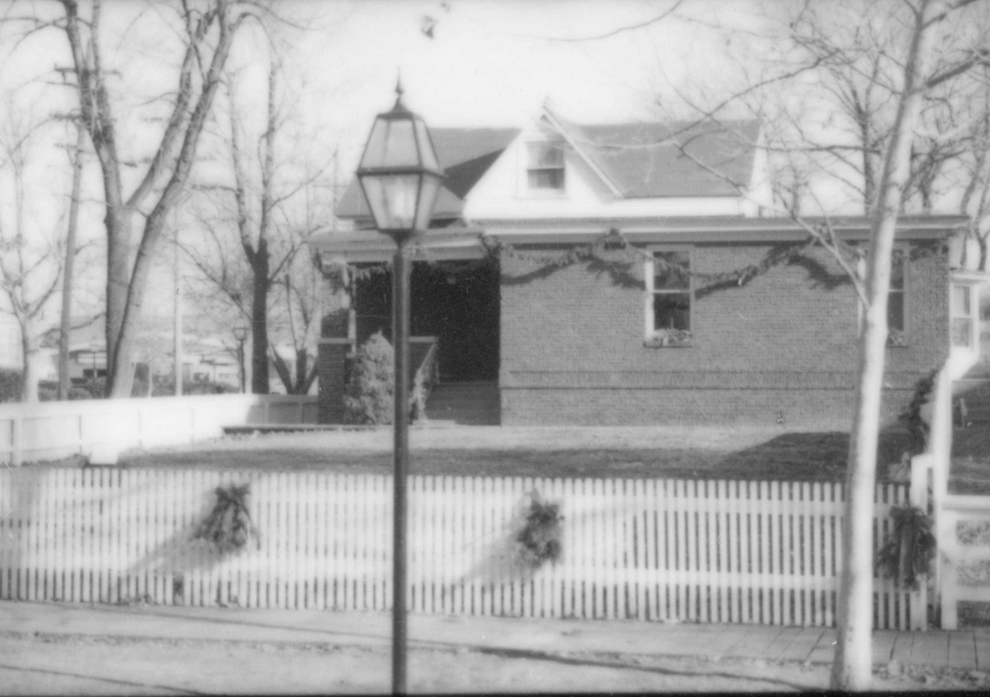 Lincoln Home NHS- Christmas in Lincoln Neighborhood Looking east from 8th Street, Christmas decor on Arnold house and fence. Christmas, neighborhood, Arnold, wreath, garland, decor