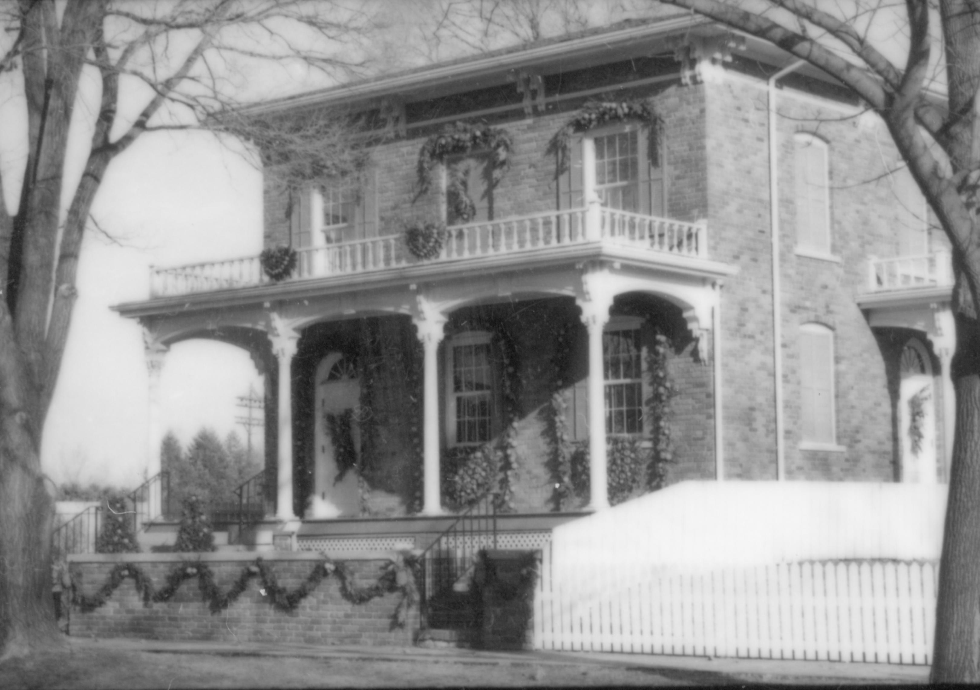 Lincoln Home NHS- Christmas in Lincoln Neighborhood Looking north east, Christmas decor on Conference Center house, retaining wall, porch, and house. Christmas, neighborhood, wall, decor, wreath, garland, porch, Conference, Center