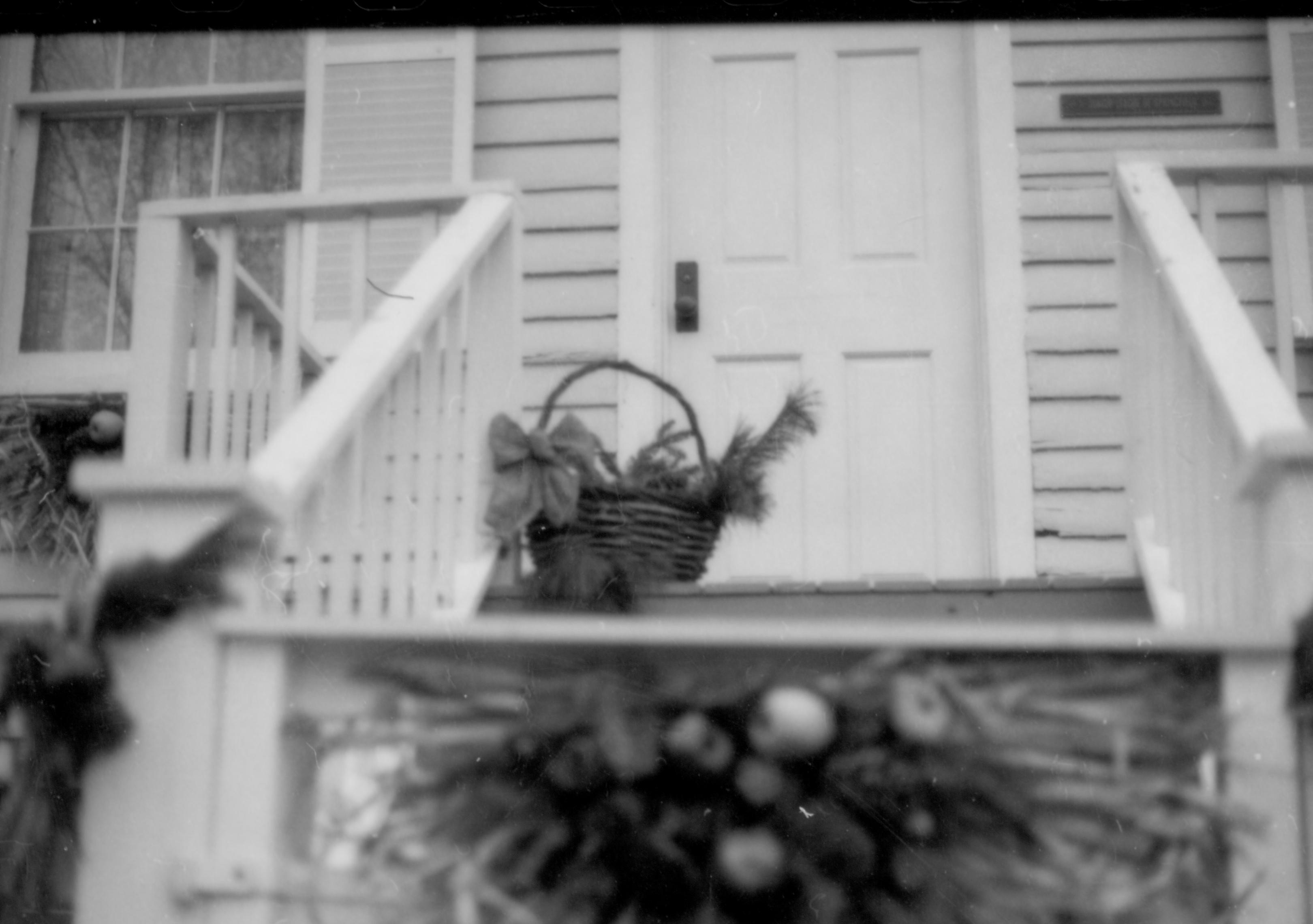 Lincoln Home NHS- Christmas in Lincoln Neighborhood Looking east, Christmas basket on porch of Corneau house, fence gate in foreground. Detail Christmas, decorations, neighborhood, porch, fence, Corneau, decor, detail