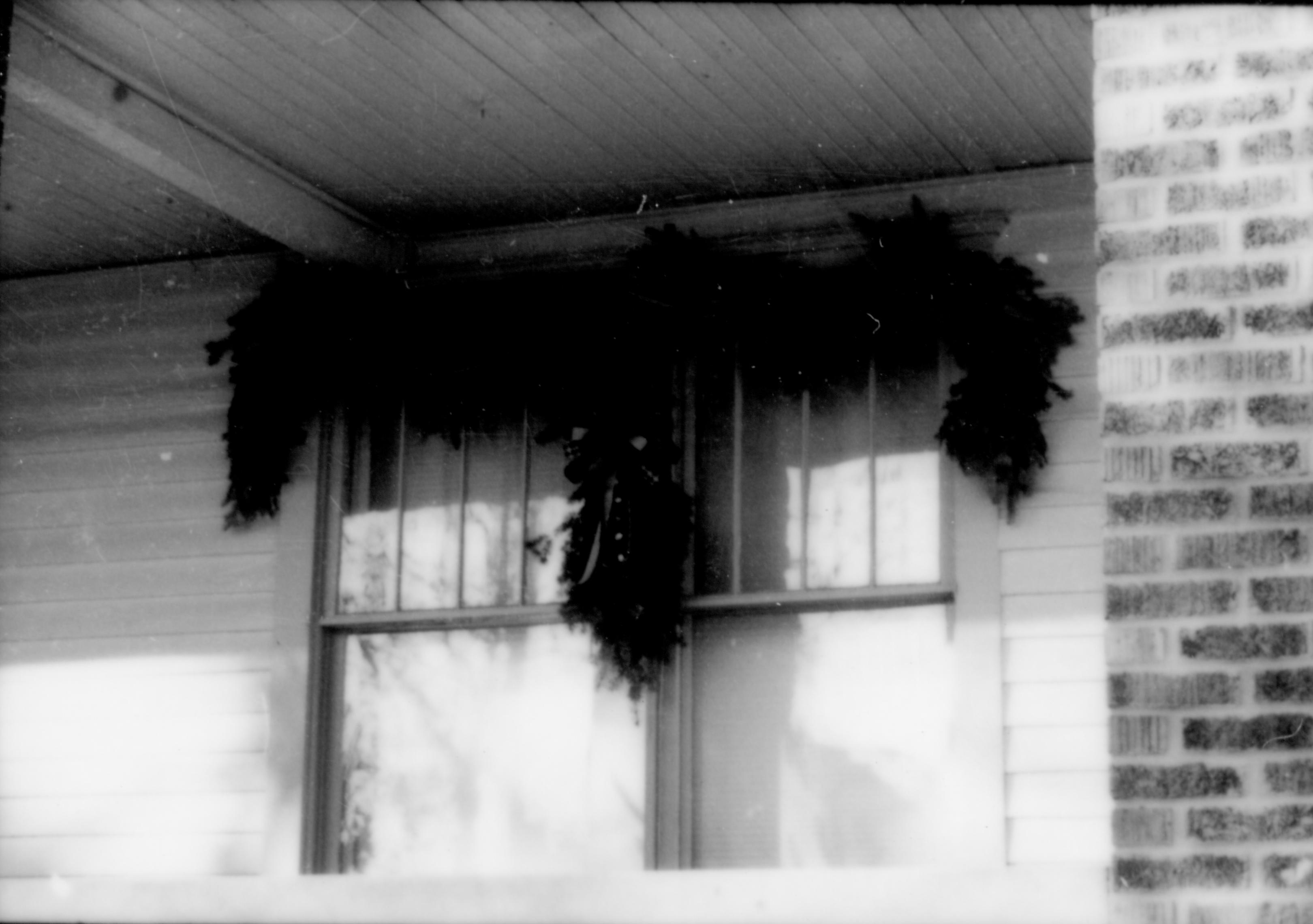 Lincoln Home NHS- Christmas in Lincoln Neighborhood Looking west from yard, Sprigg house porch decorated for Christmas. Detail. Christmas, neighborhood, decorations, porch, window, garland, Sprigg