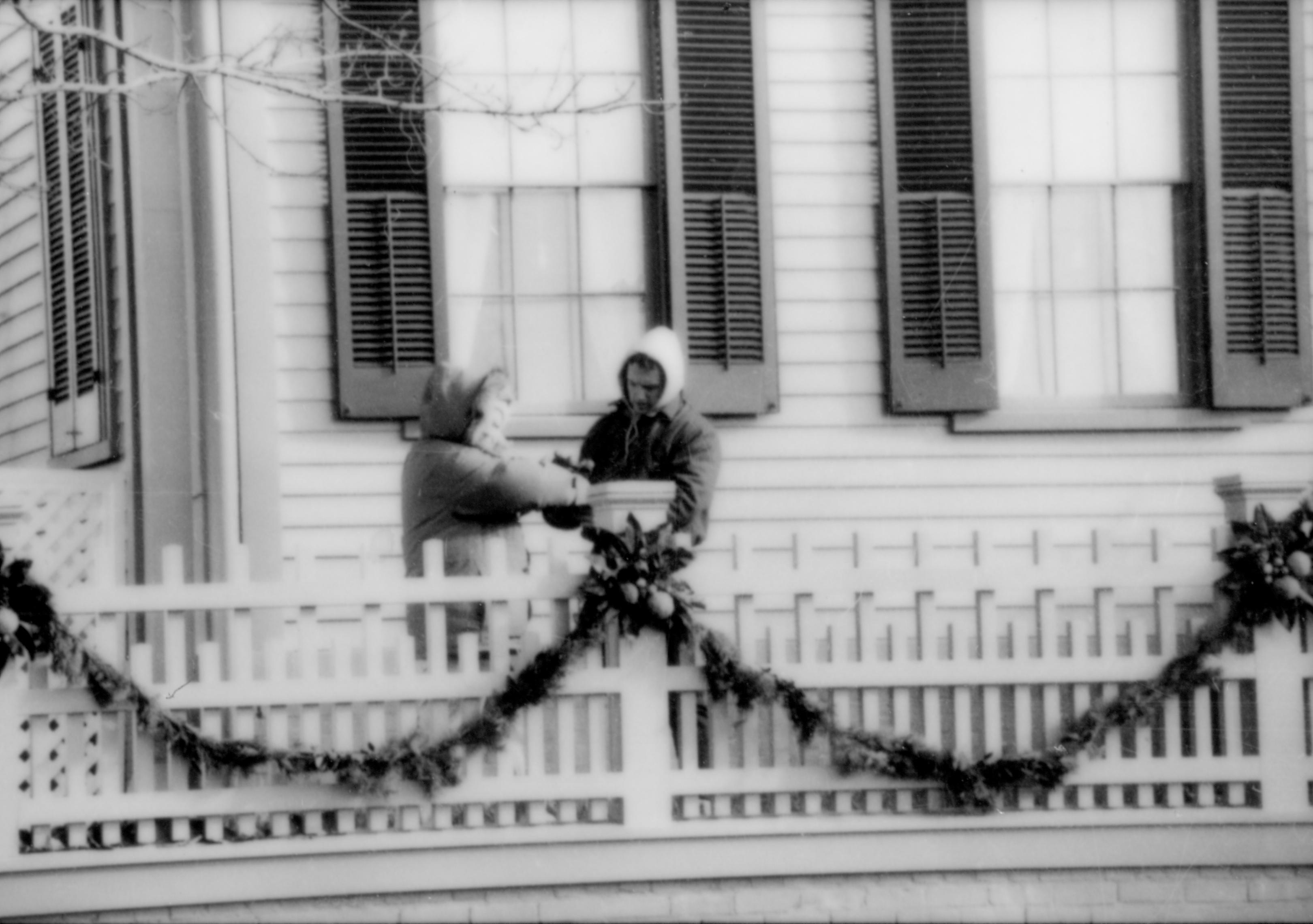 Lincoln Home NHS- Christmas in Lincoln Neighborhood Looking east from 8th Street, people decorating Lincoln home fence for Christmas. Christmas, neighborhood, decorations, garland, Lincoln, fence, decor