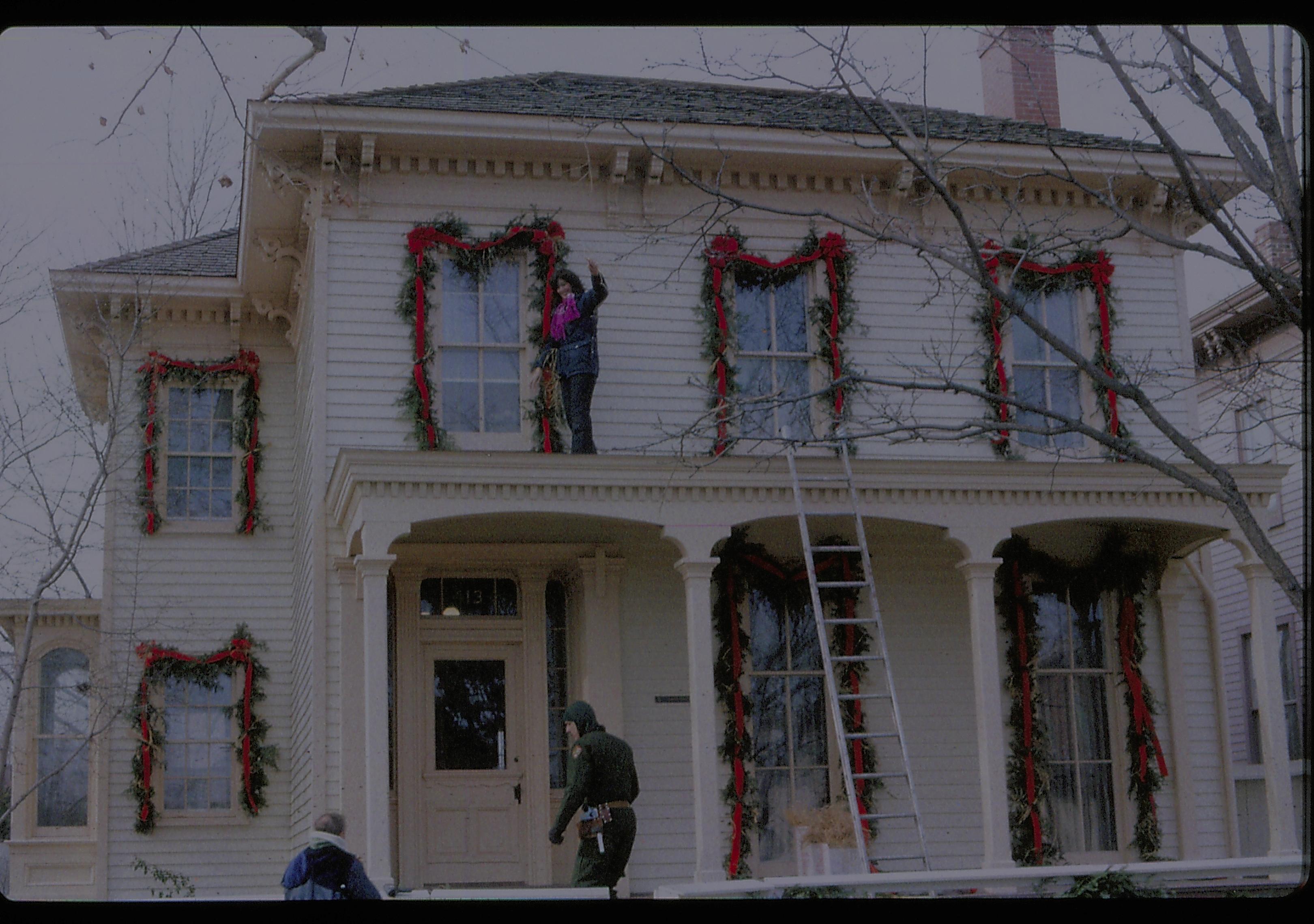 Lincoln Home NHS- Christmas in Lincoln Neighborhood Looking west from 8th Street, staff decorating Rosenwald house for Christmas. Christmas, decorations, staff, Rosenwald, Lyon, decor, garland