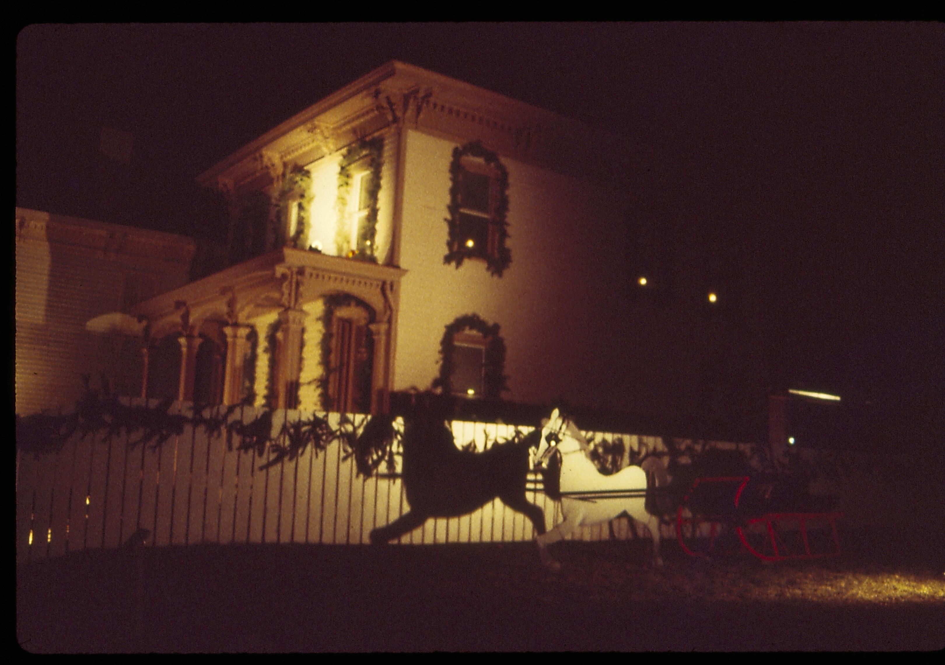 Lincoln Home NHS- Christmas in Lincoln Neighborhood Looking south from Worthen lot, Beedle house decorated for Christmas. Night. Christmas, decorations, night, Beedle, garland, Worthen, wreath, sleigh.