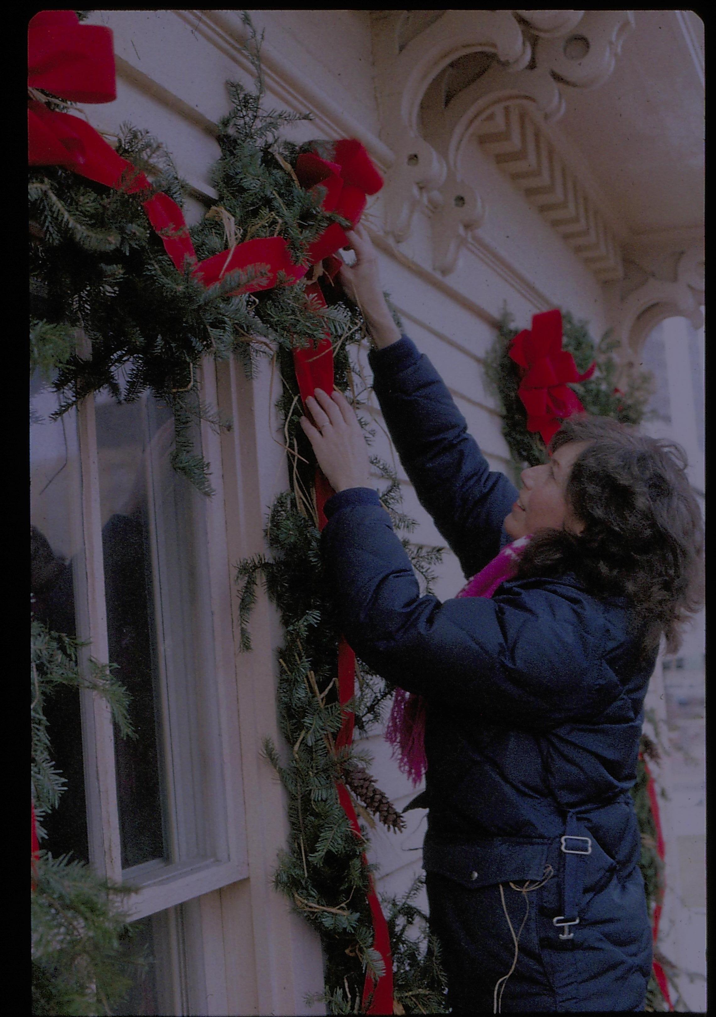 Lincoln Home NHS- Christmas in Lincoln Neighborhood Staff hanging garland on east face of Rosenwald house. Christmas, decorations, staff, garland, wreath, decor, Rosenwald, Lyon