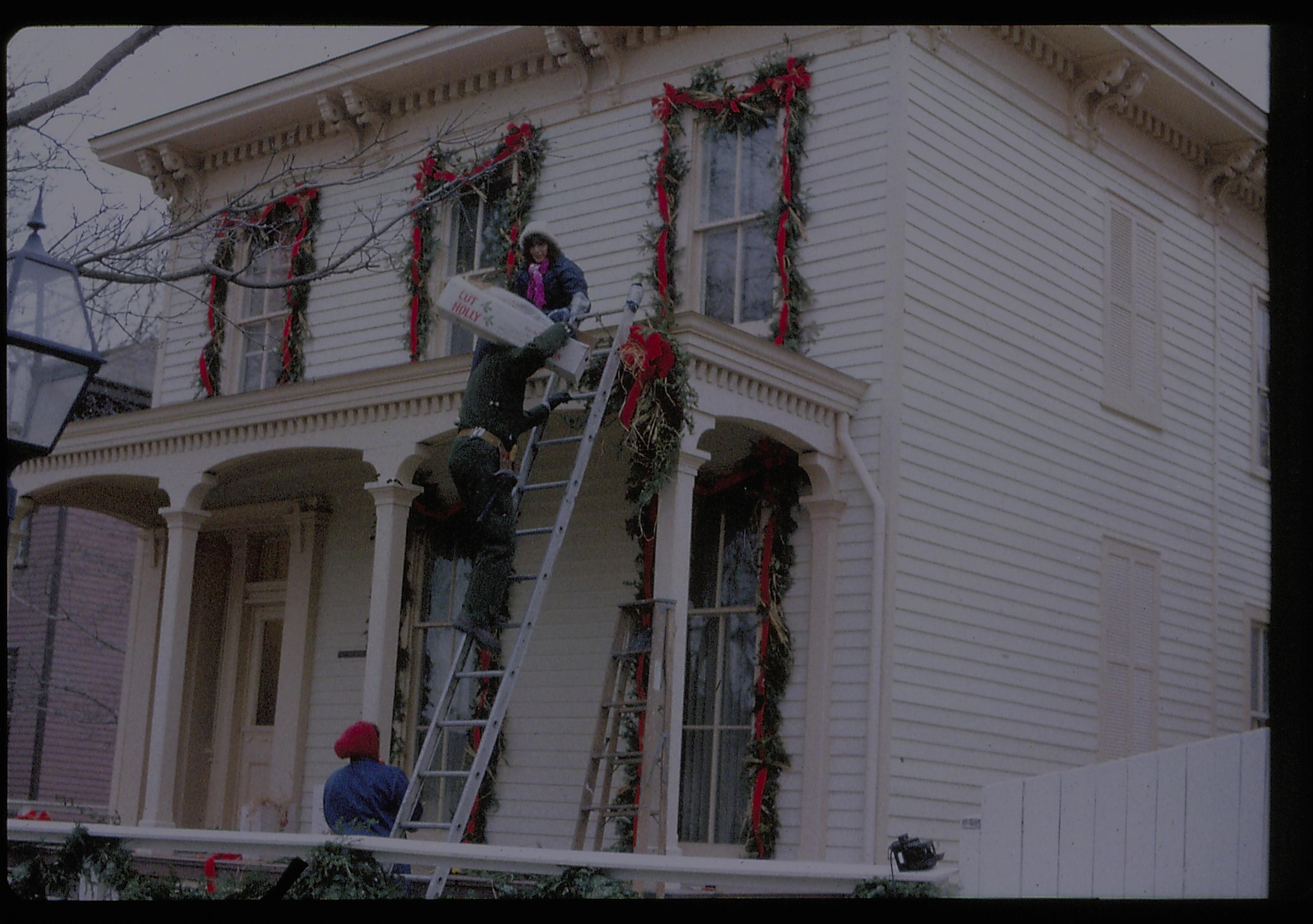 Lincoln Home NHS- Christmas in Lincoln Neighborhood Looking south west from boardwalk, staff hanning garland on east face of Rosenwald house. Christmas, decorations, Rosenwald, Lyon, staff, garland