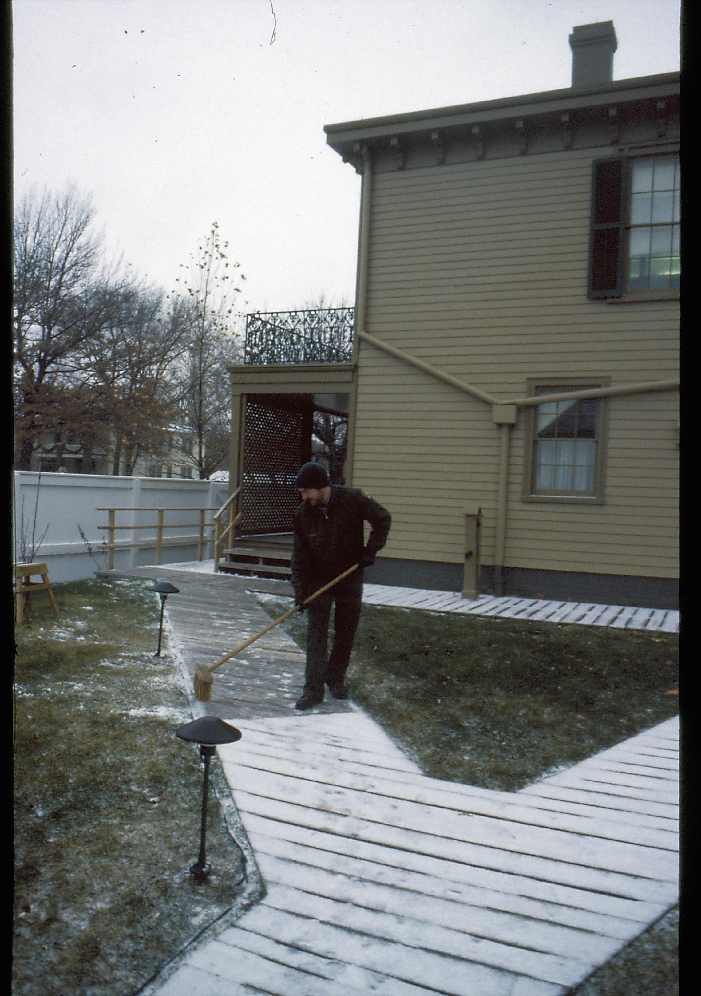 Lincoln Home NHS- Christmas in Lincoln Neighborhood Looking south west from boardwalk, staff sweeping Lincoln home back yard boardwalk. Christmas, decorations, staff, Lincoln, yard, boardwalk, snow