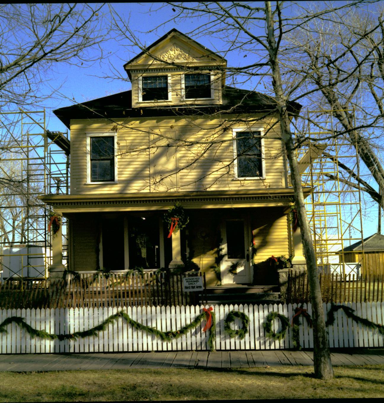 Lincoln Home NHS- Christmas in Lincoln Neighborhood Looking east from 8th Street, Cook house west face decorated for Christmas. Christmas, decorations, Cook, wreath, garland, fence, porch, decor, scaffolding