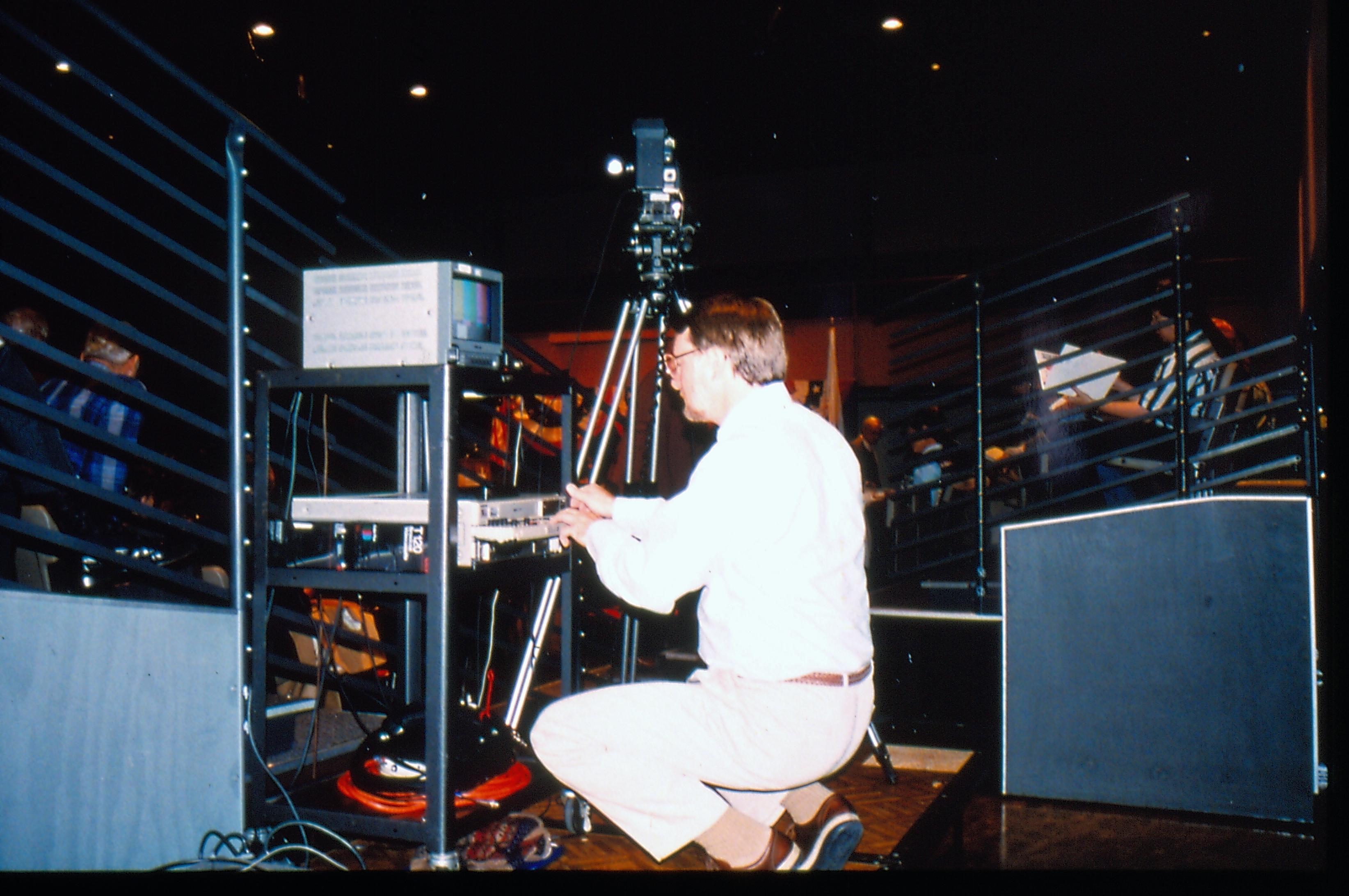 Man adjusting video equipment. 1997 Colloq (color slides) Colloquium, 1997