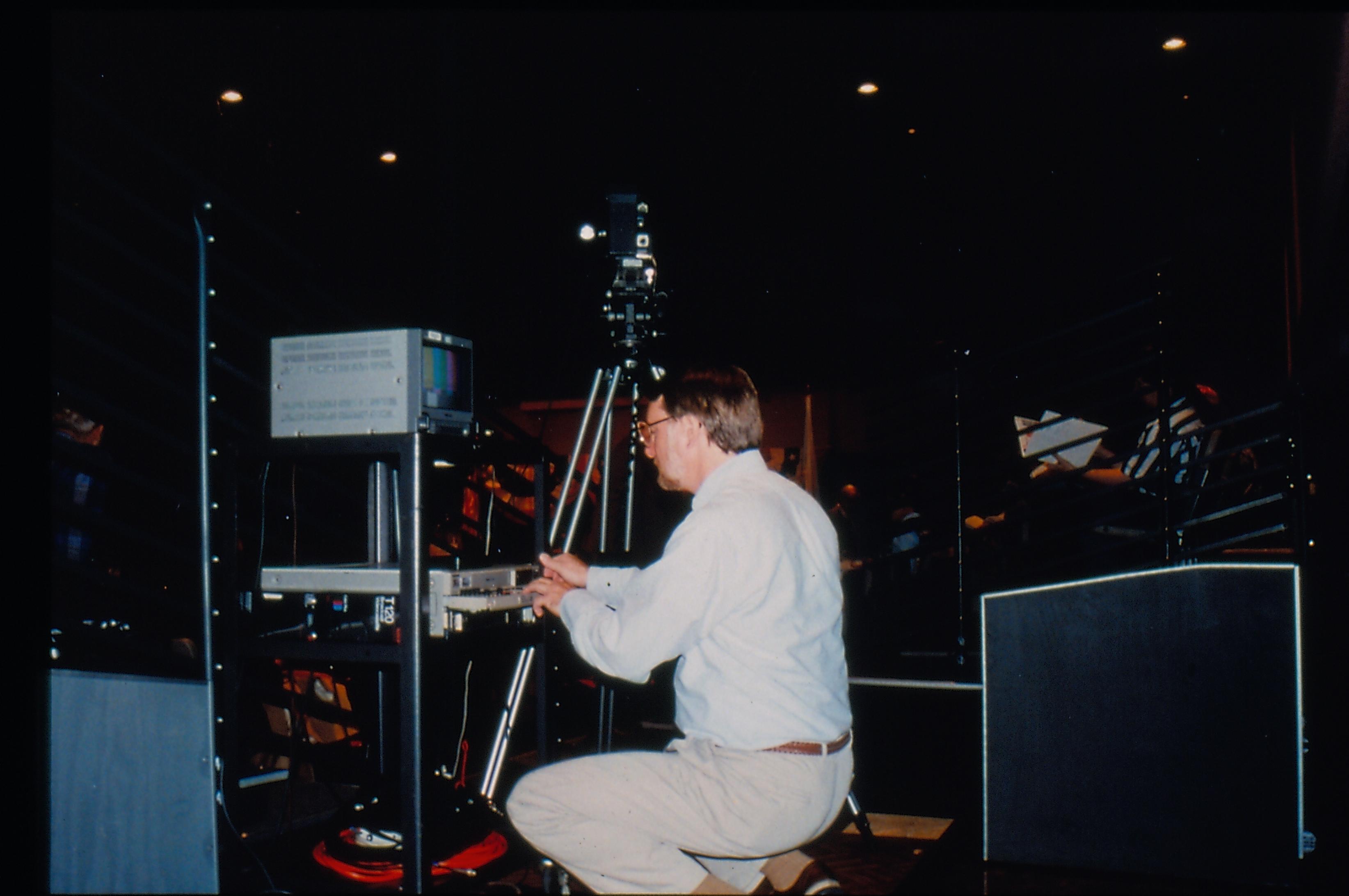 Man adjusting video equipment. 1997 Colloq (color slides) Colloquium, 1997