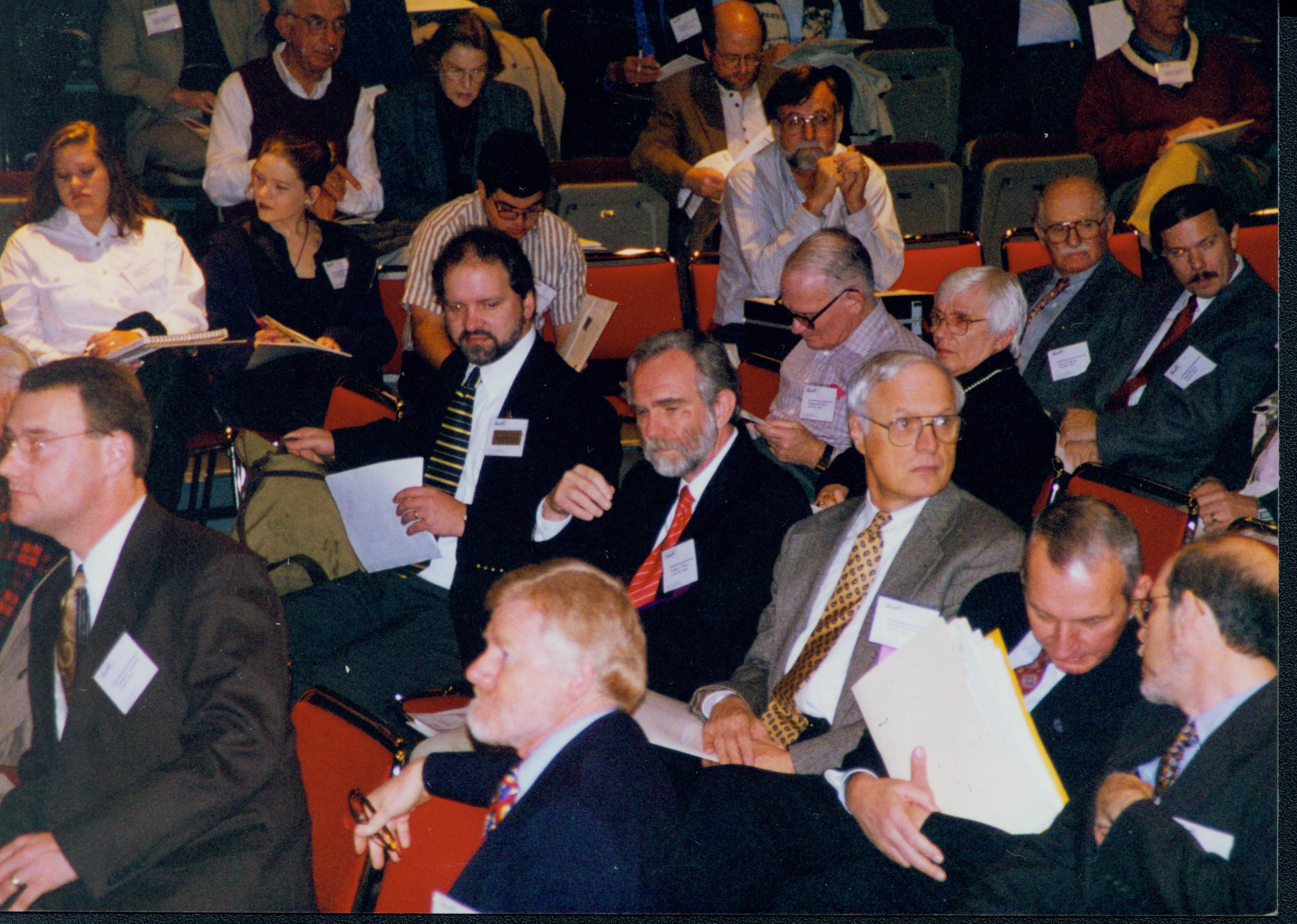 Men seated holding papers. 1-1997 Colloq (color); 11 Colloquium, 1997