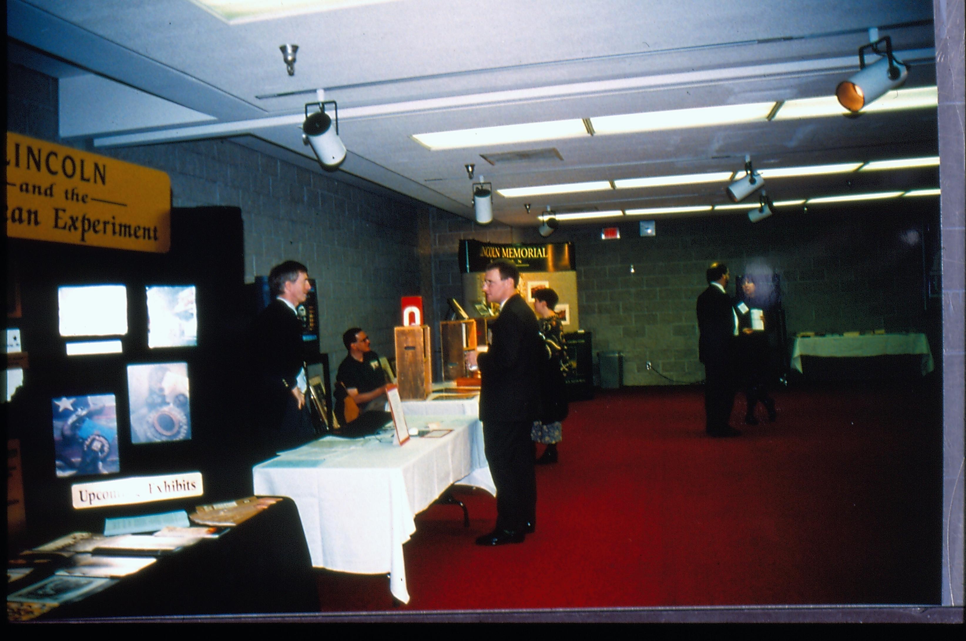 Man standing in front of exhibit table. 1997 Colloq (color slides) Colloquium, 1997
