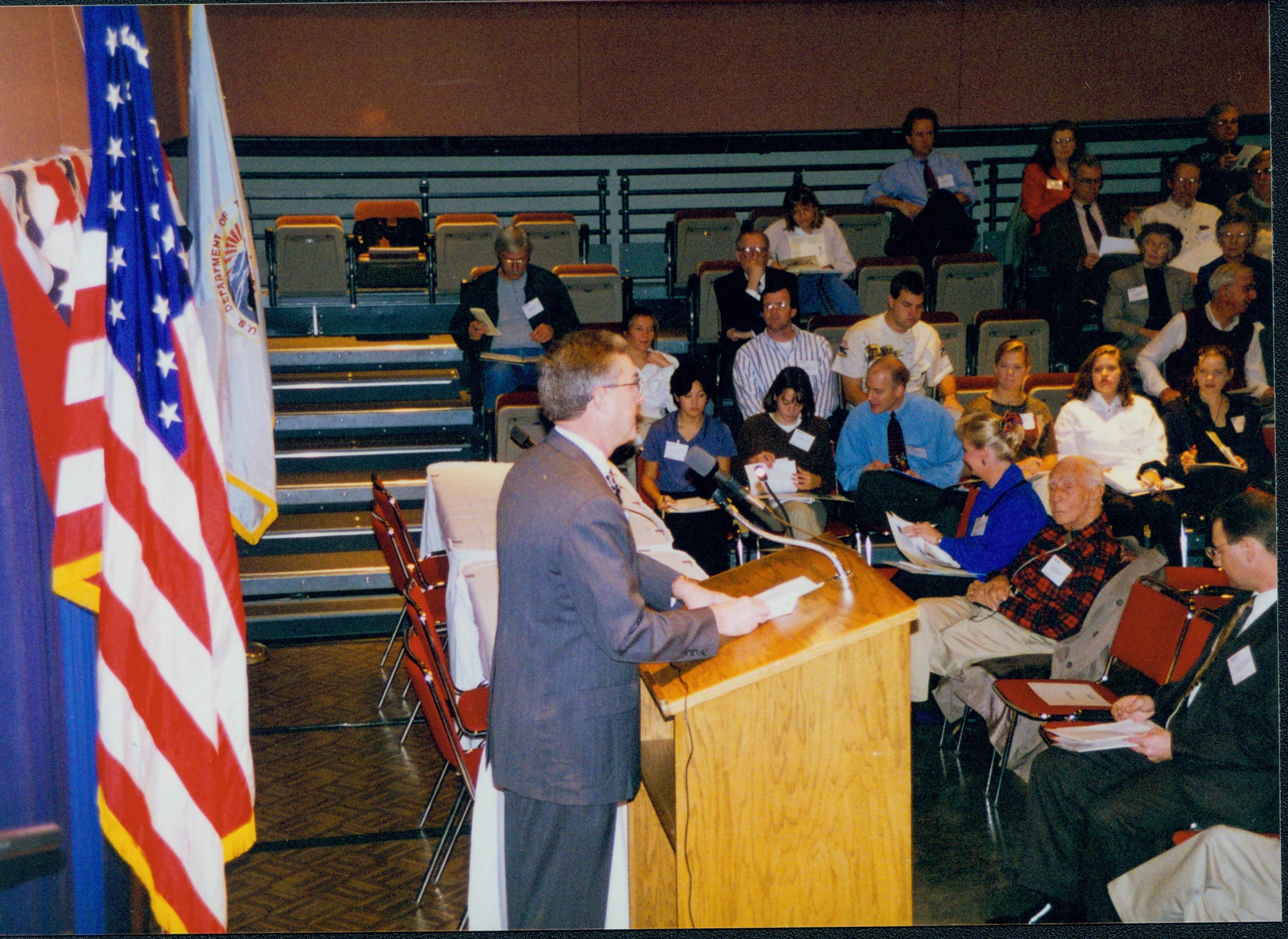 Man speaking at podium (side view). 1-1997 Colloq (color); 12 Colloquium, 1997