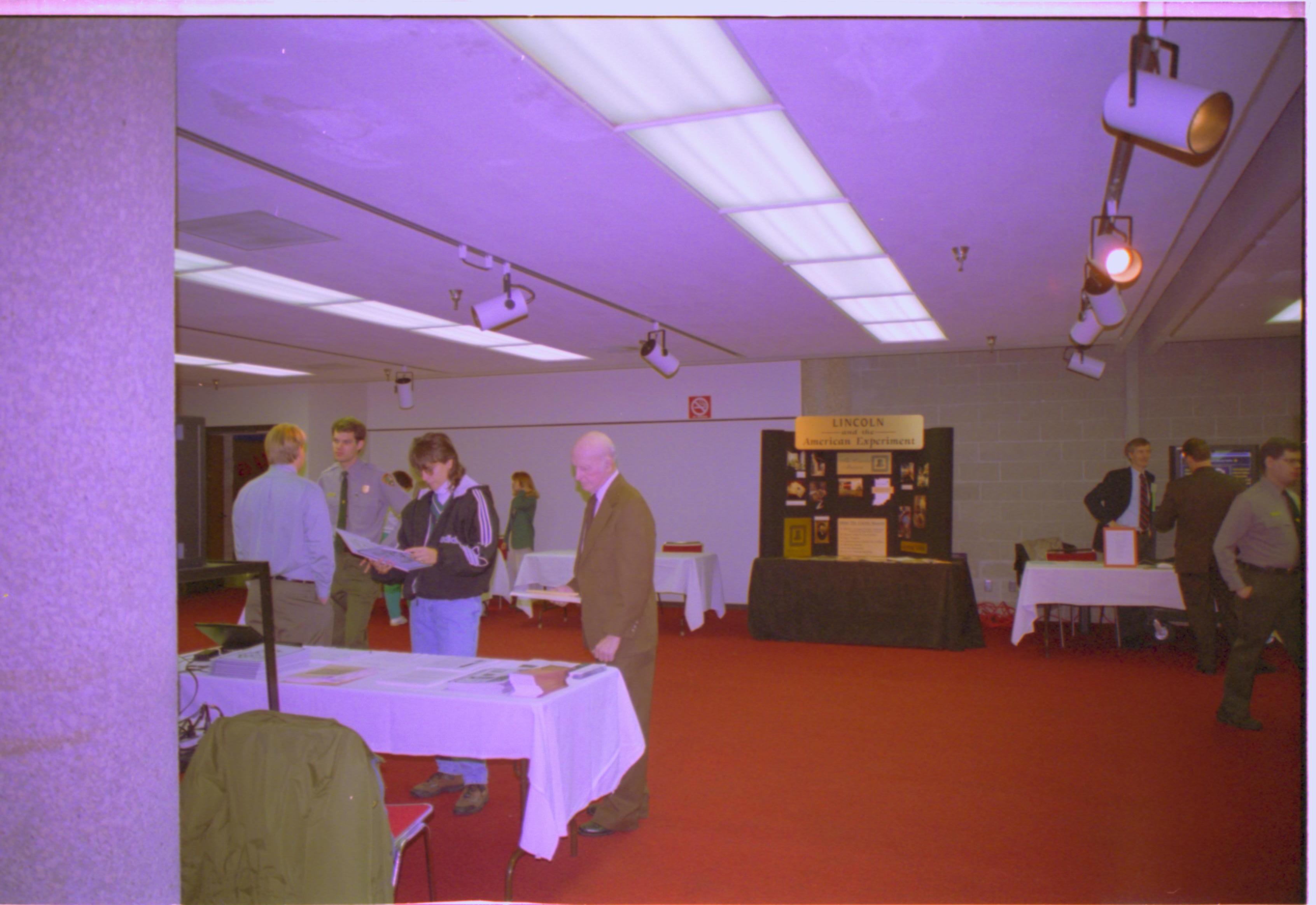 Attendees at literature table. 4-1997 Colloq (color); 7 Colloquium, 1997