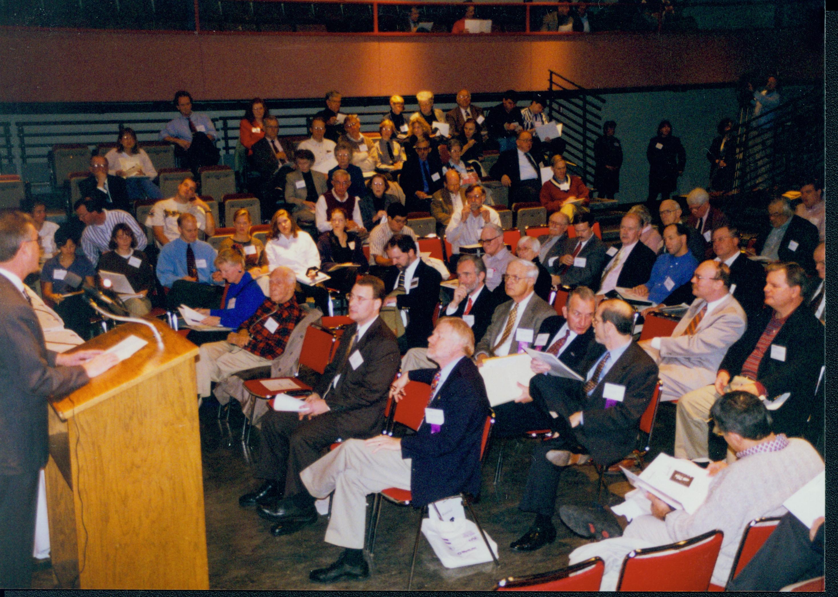 Man at podium and attendees. 1-1997 Colloq (color); 13 Colloquium, 1997