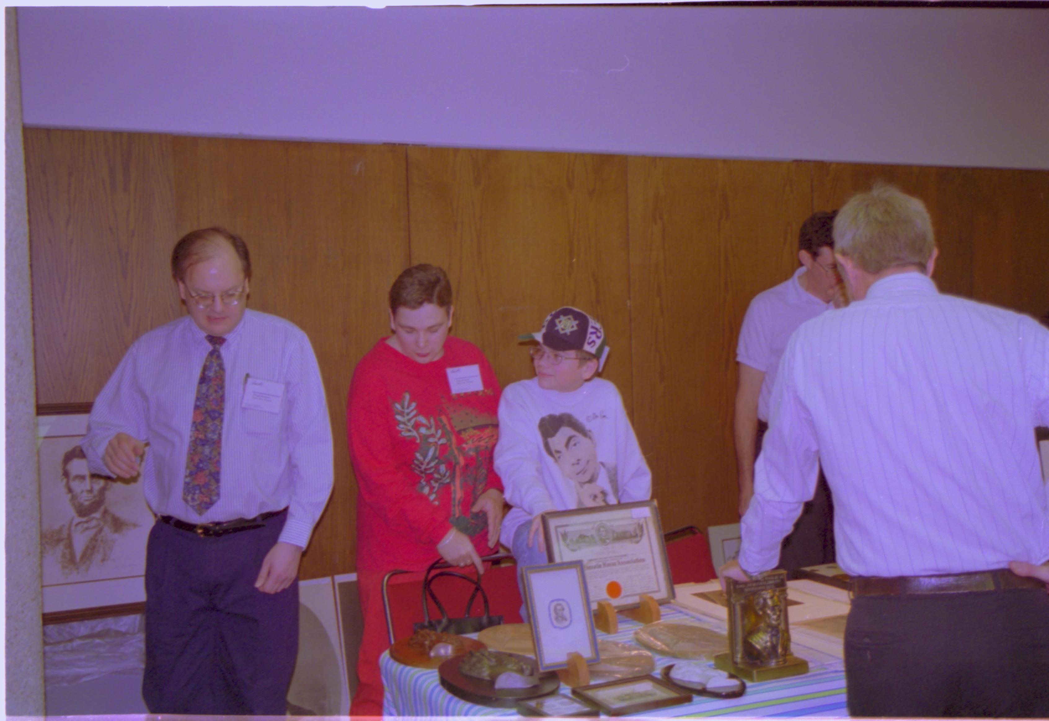 Attendees at exhibitor table. 4-1997 Colloq (color); 12 Colloquium, 1997