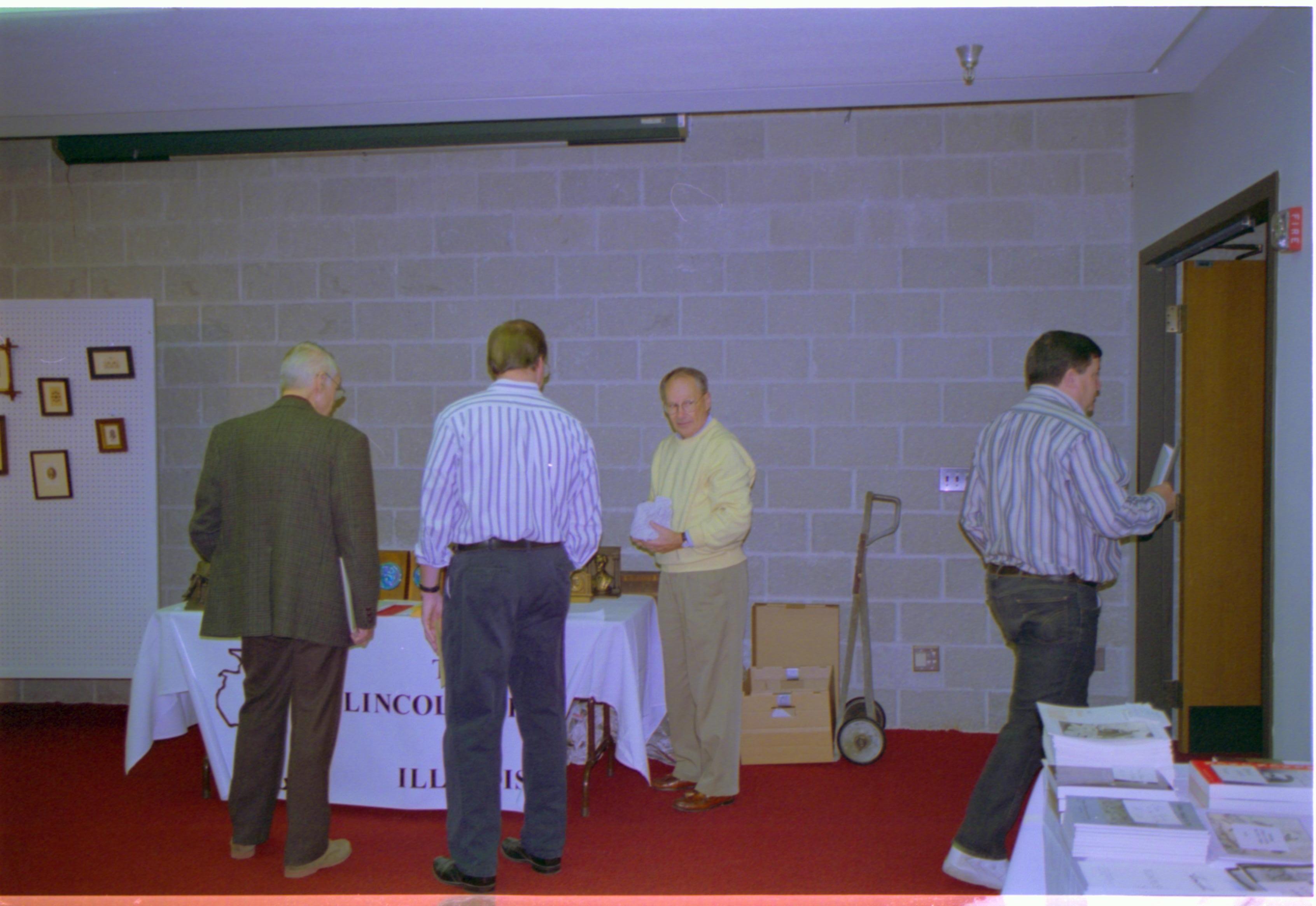 Attendees at exhibitor table. 4-1997 Colloq (color); 32 Colloquium, 1997