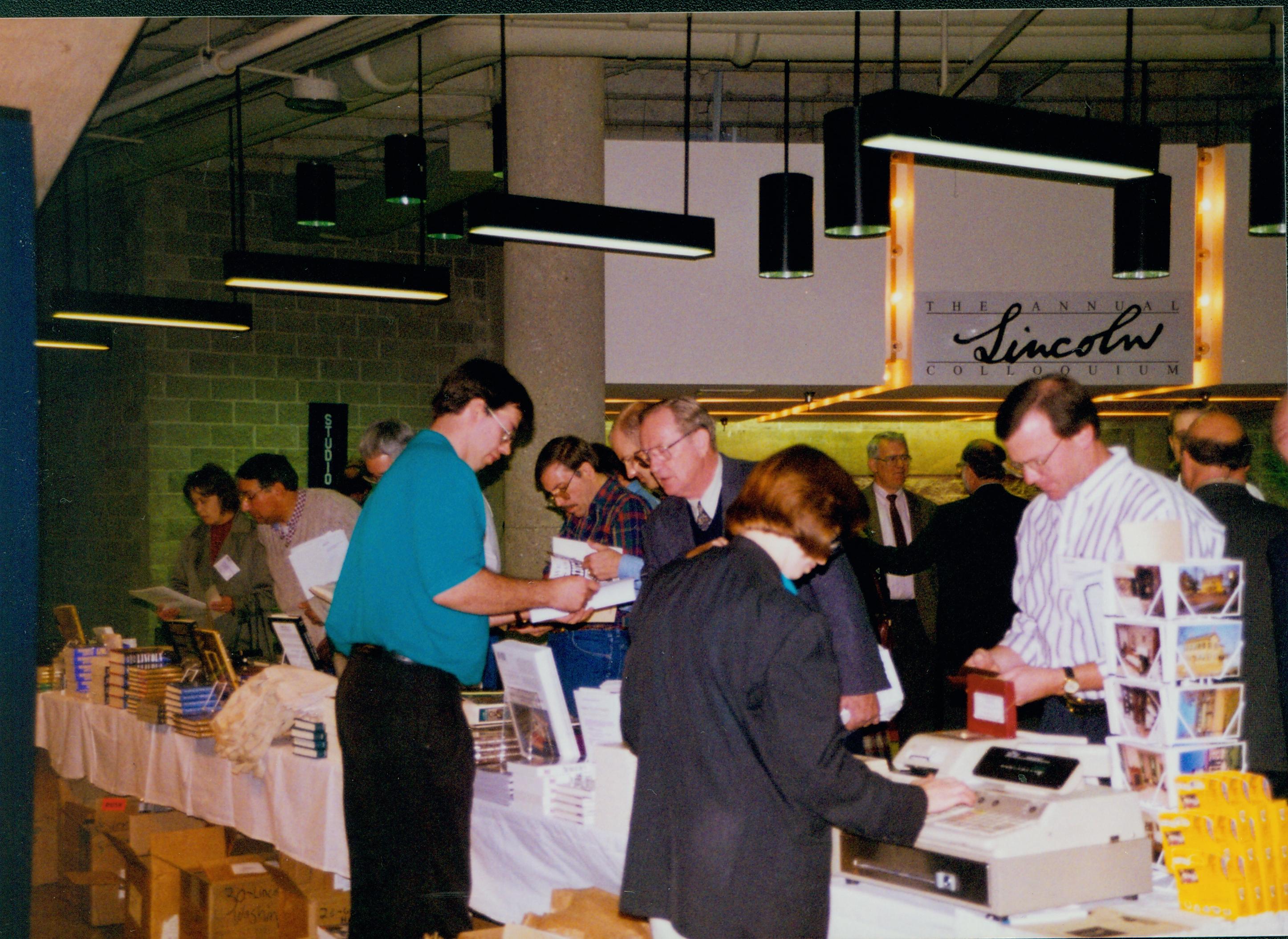 Attendees at book table. 1-1997 Colloq (color); 16 Colloquium, 1997