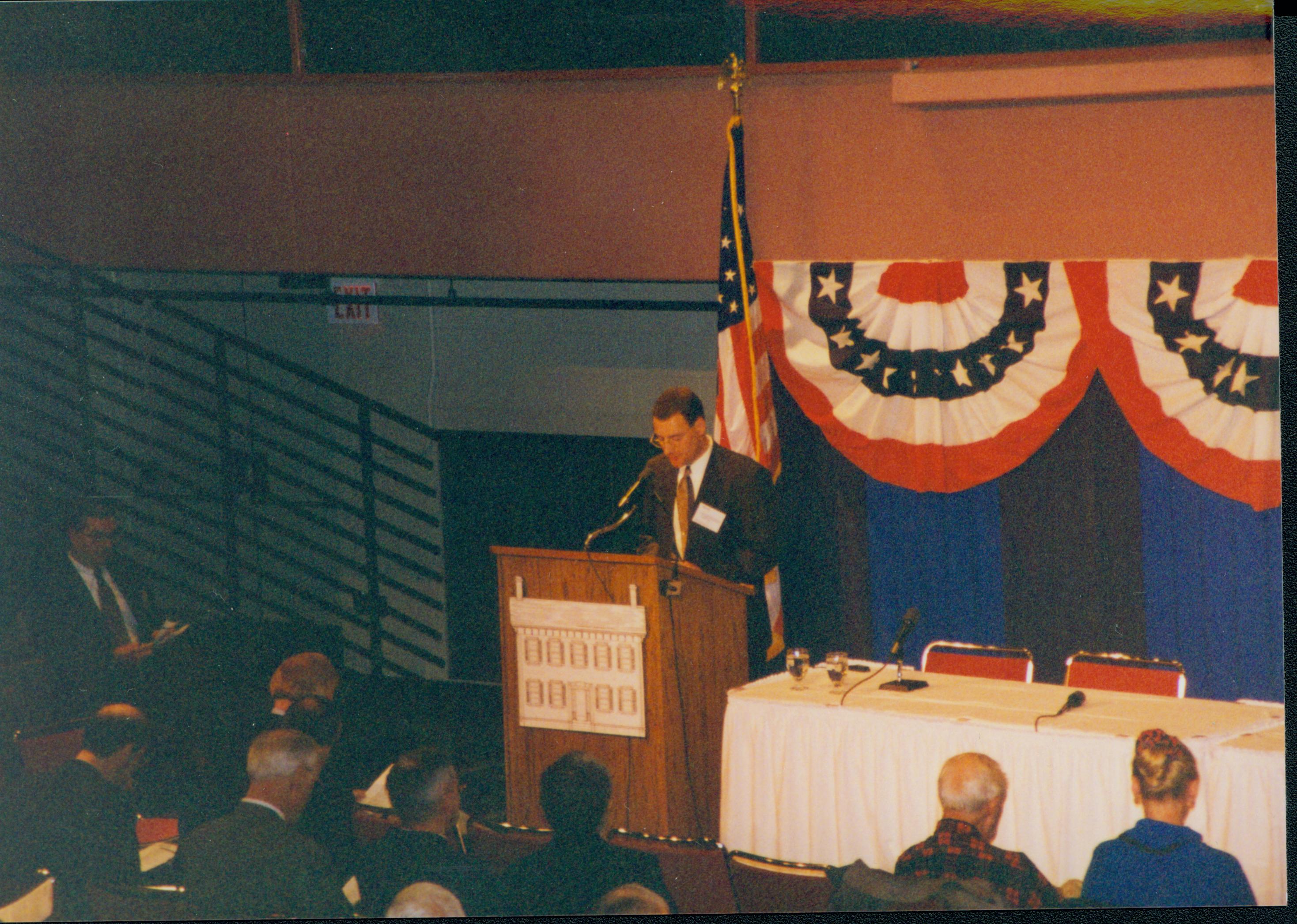 Man at podium. 1-1997 Colloq (color); 19 Colloquium, 1997