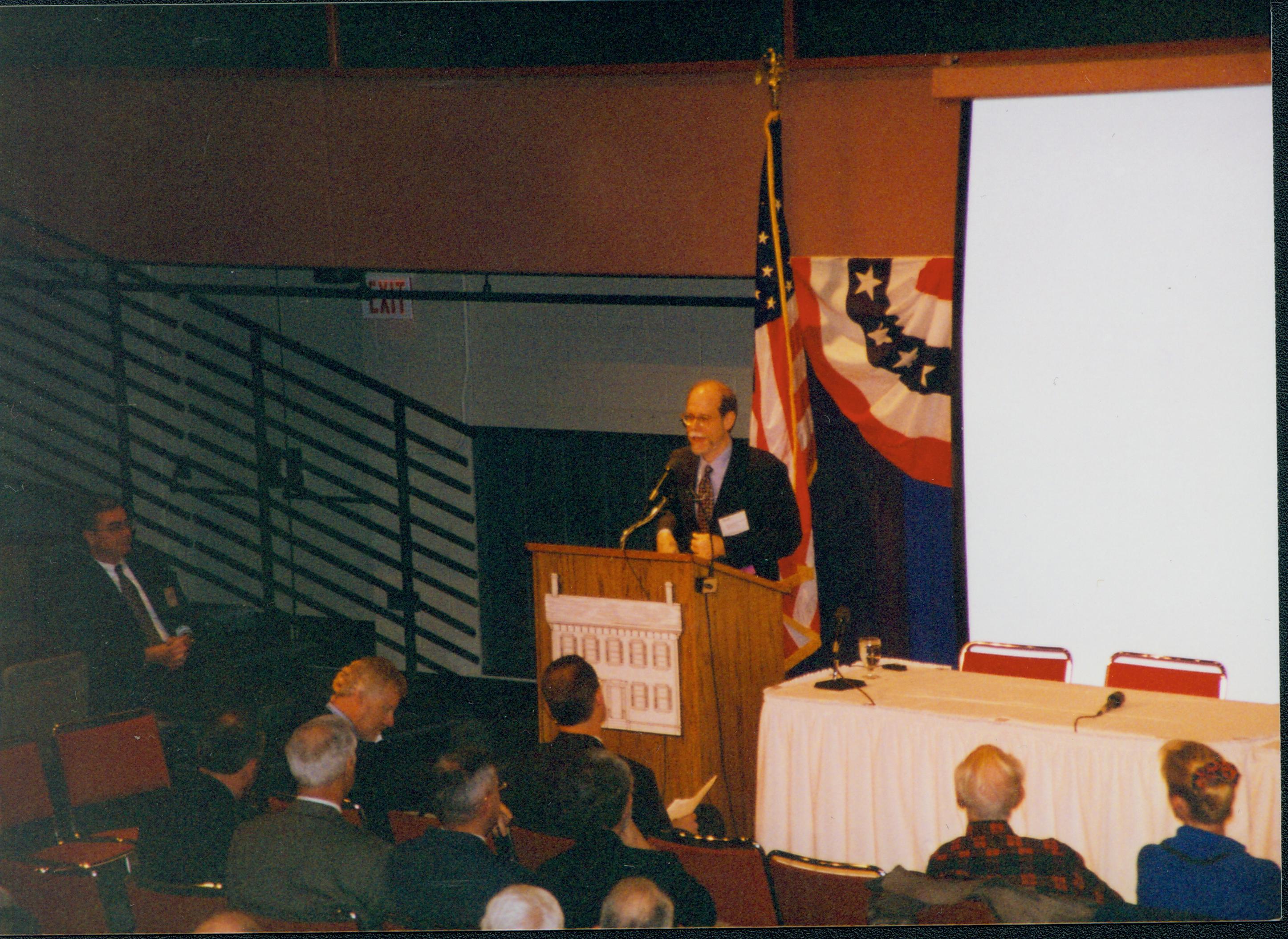 Man speaking, screen behind him. 1-1997 Colloq (color); 26 Colloquium, 1997