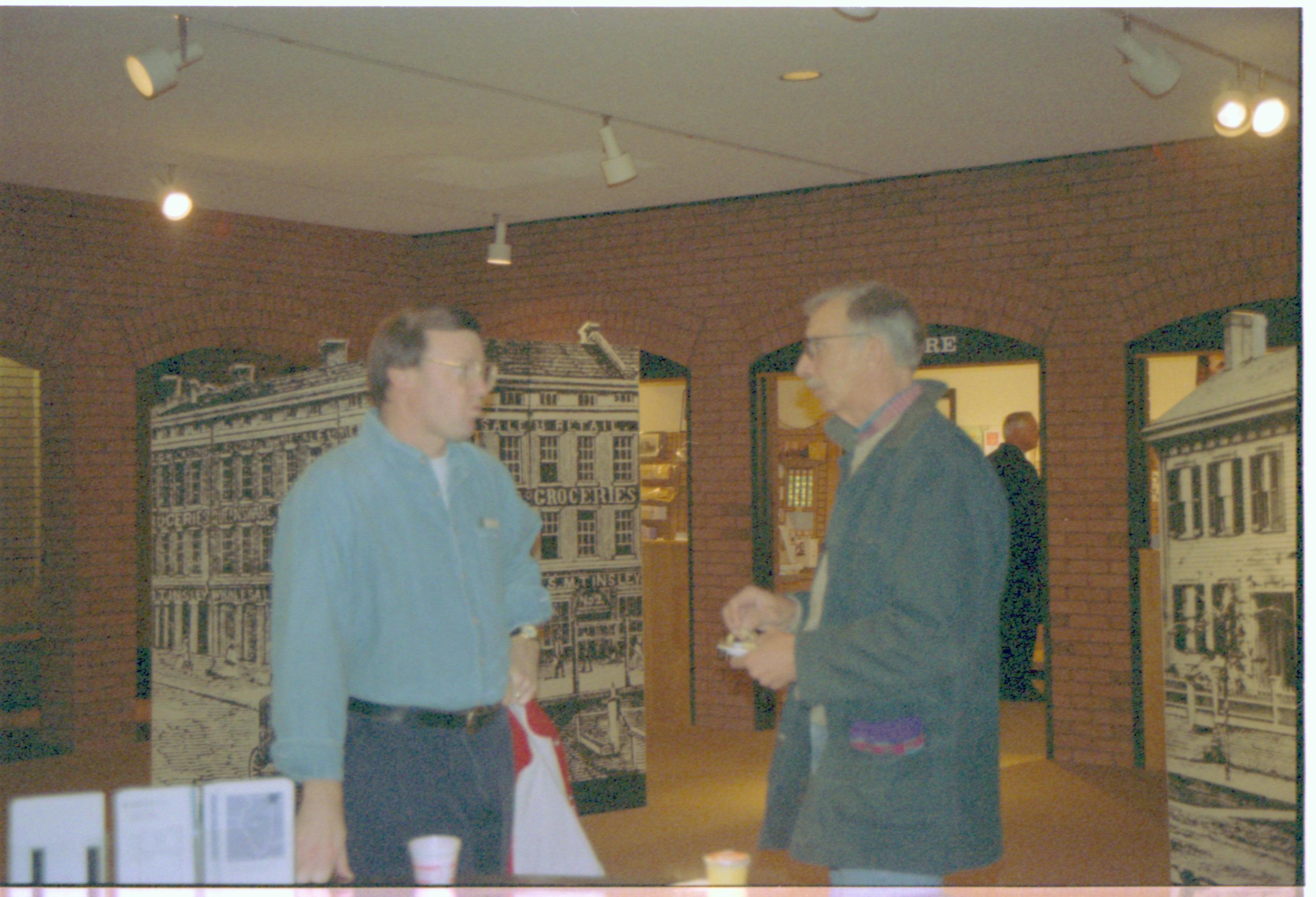 Two men standing, talking in VC. 2-1997 Colloq (color); 1 Colloquium, 1997