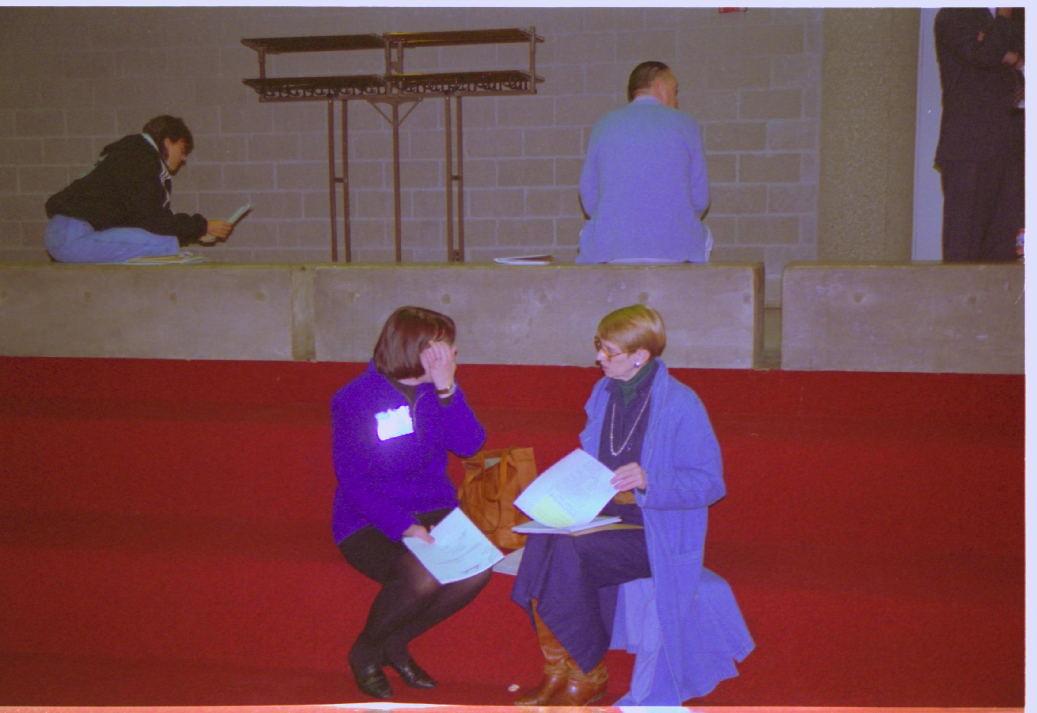 Two ladies seated on steps talking. 3-1997 Colloq (color); 3 Colloquium, 1997