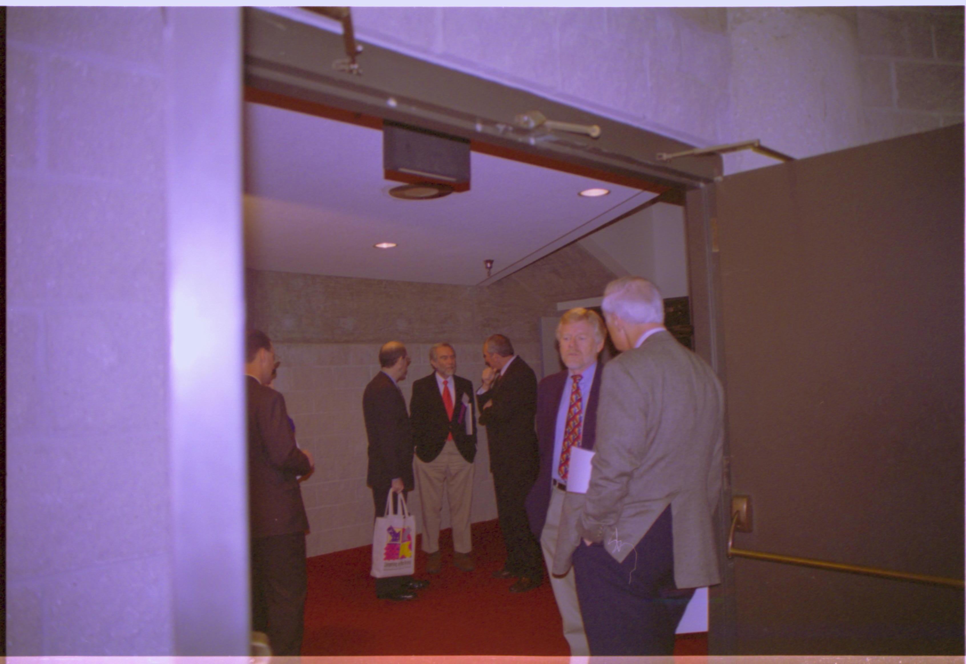 Two men standing in doorway talking. 3-1997 Colloq (color); 10 Colloquium, 1997