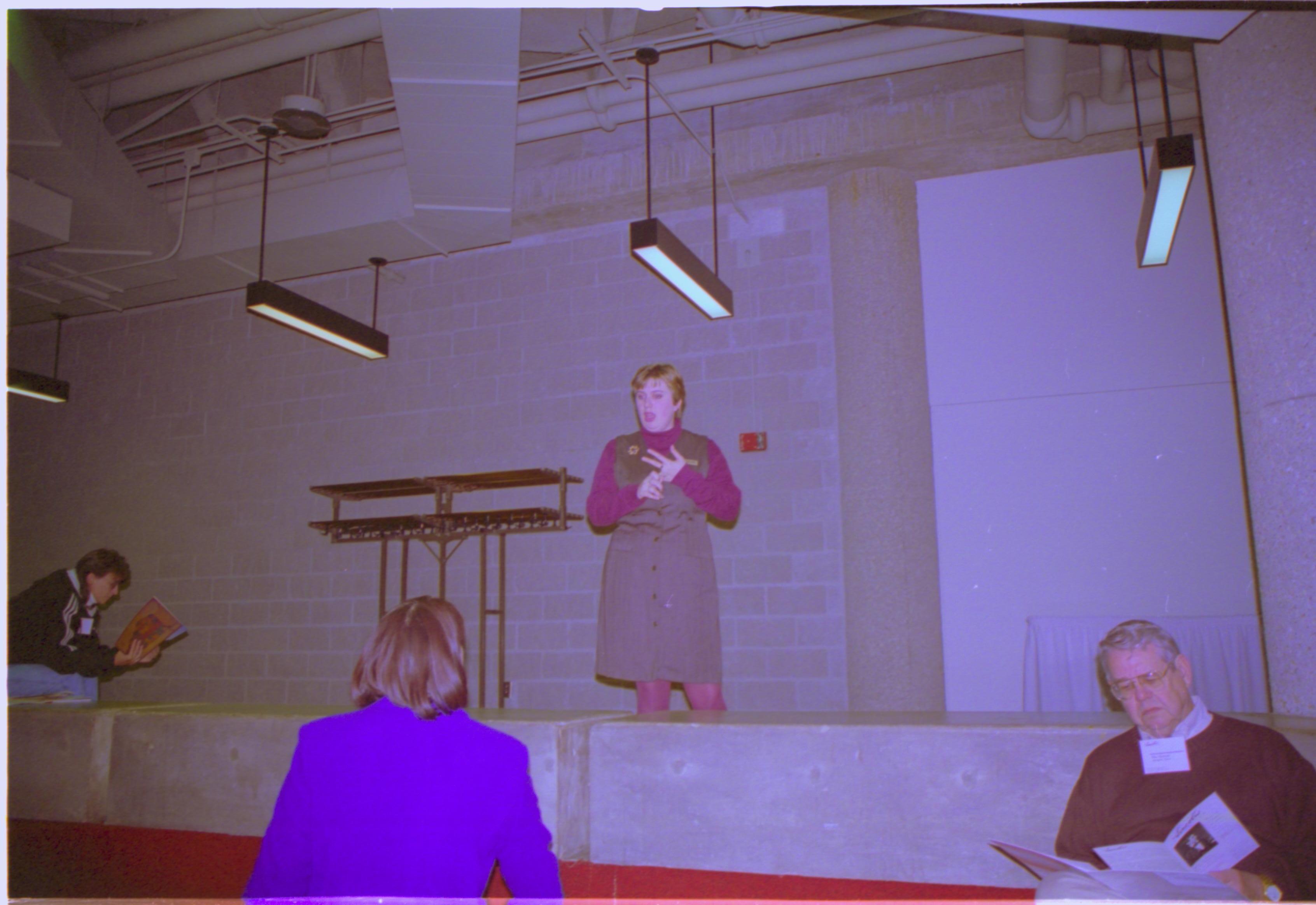 Two ladies talking to each other (man sitting on steps). 3-1997 Colloq (color); 12 Colloquium, 1997