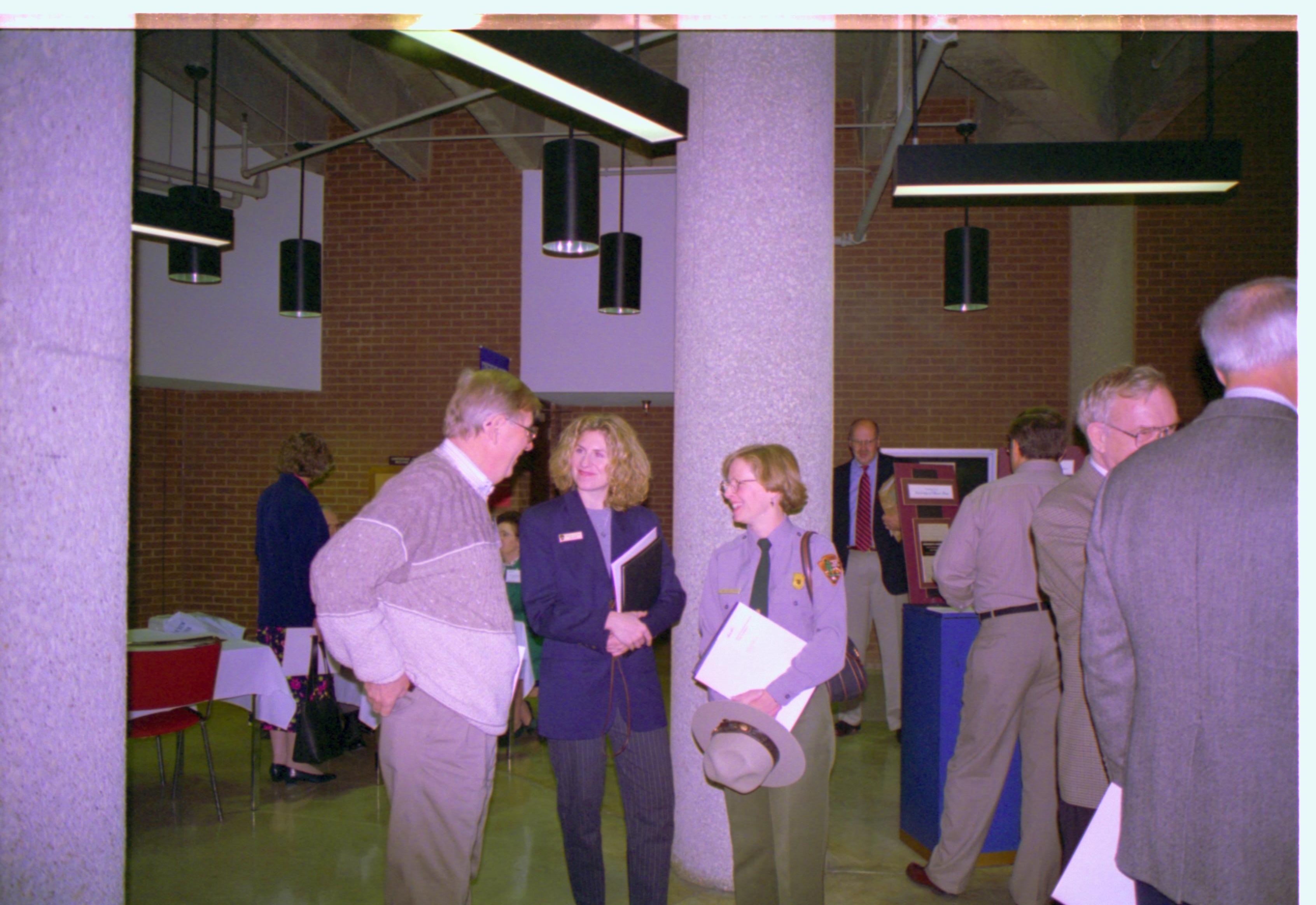 Ranger talking with man and woman in exhibit hall. 3-1997 Colloq (color); 21 Colloquium, 1997