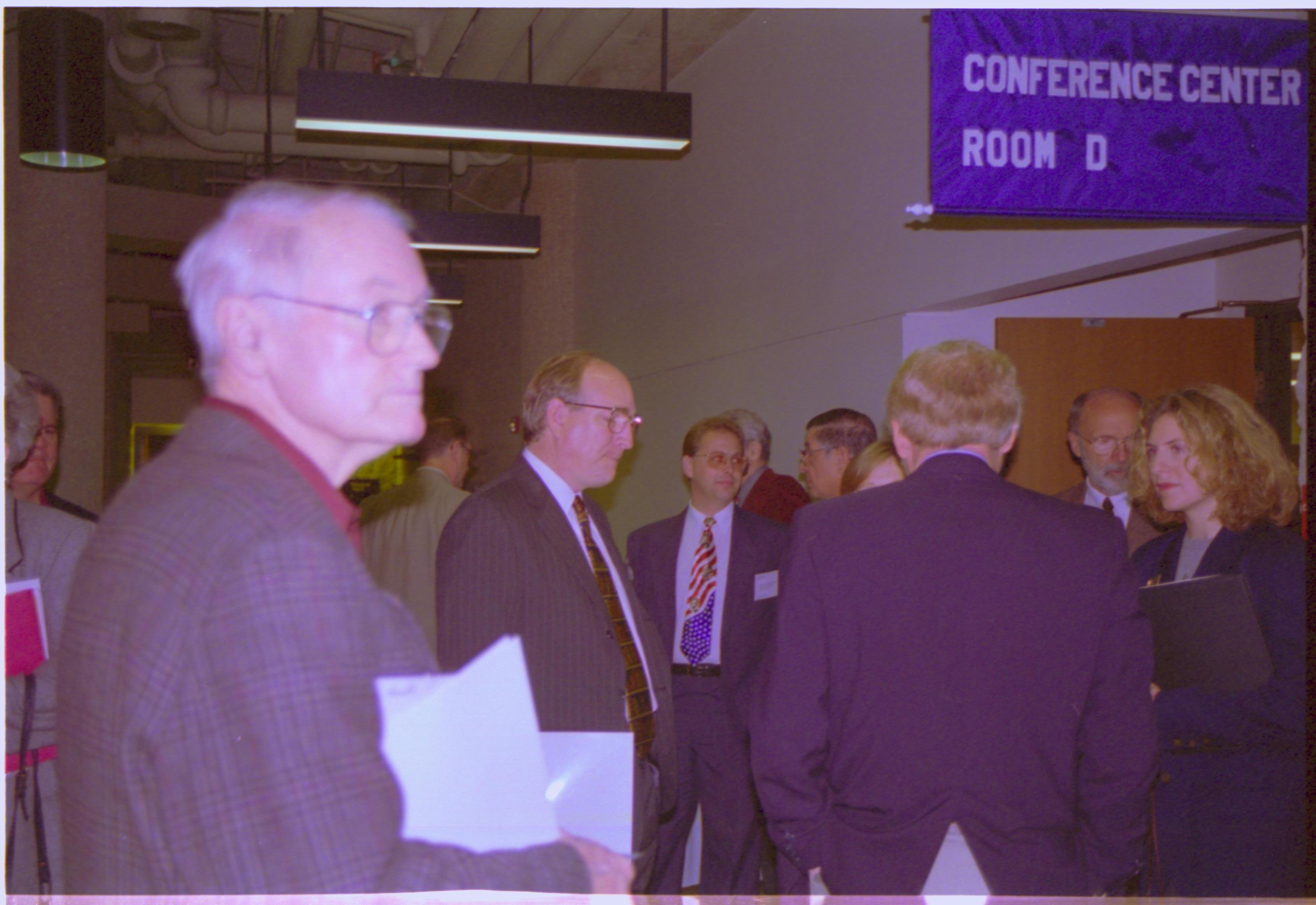 Group standing outside door way talking. 3-1997 Colloq (color); 27 Colloquium, 1997