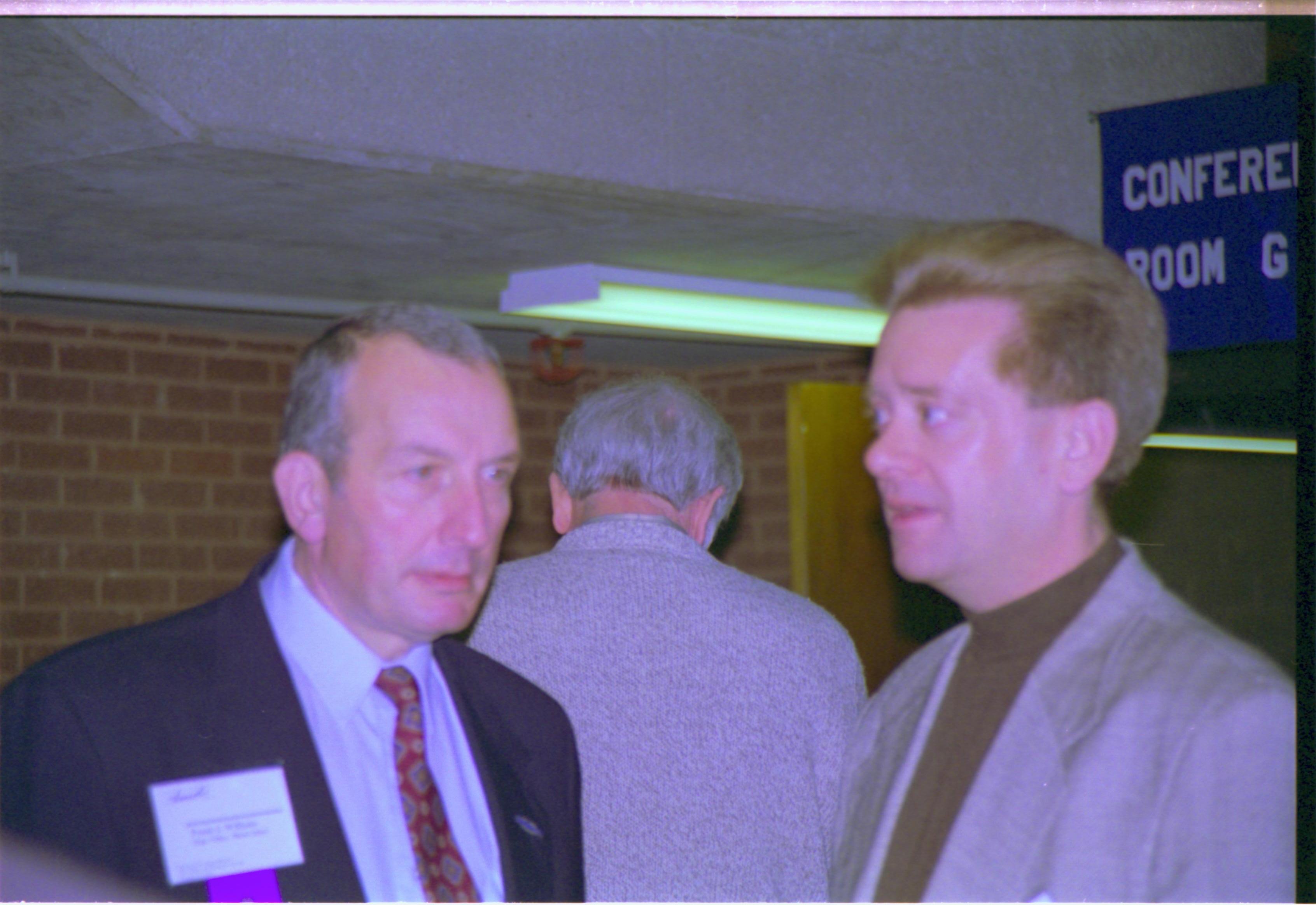 Close up of two men talking. 3-1997 Colloq (color); 29 Colloquium, 1997