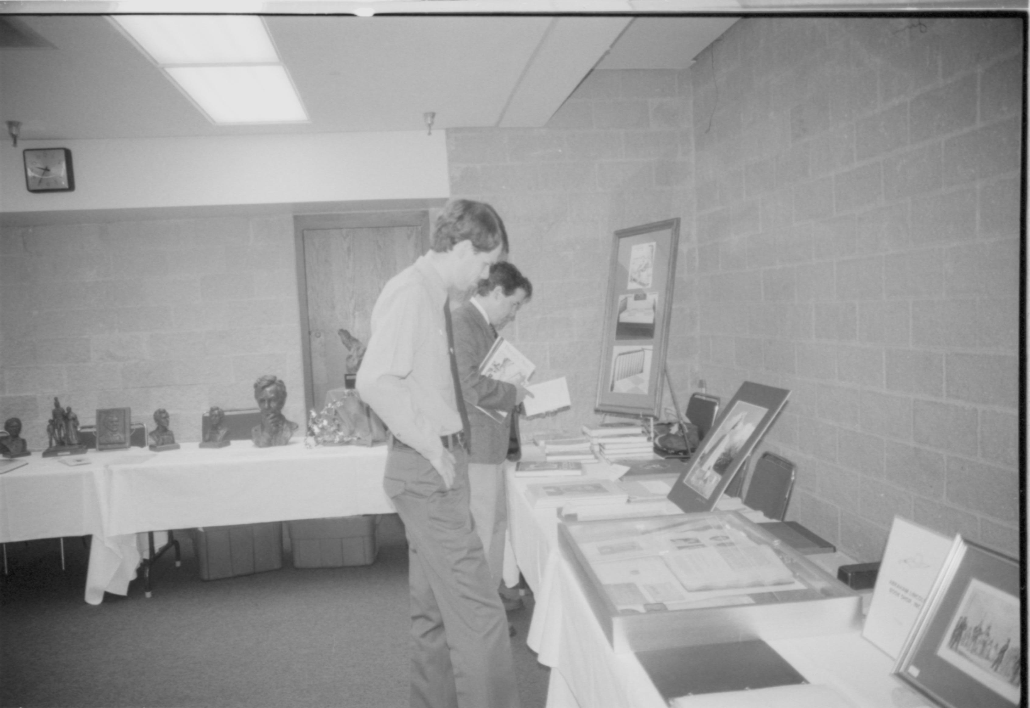 Ranger peruses the exhibits 1999-16; 10 Colloquium, 1999