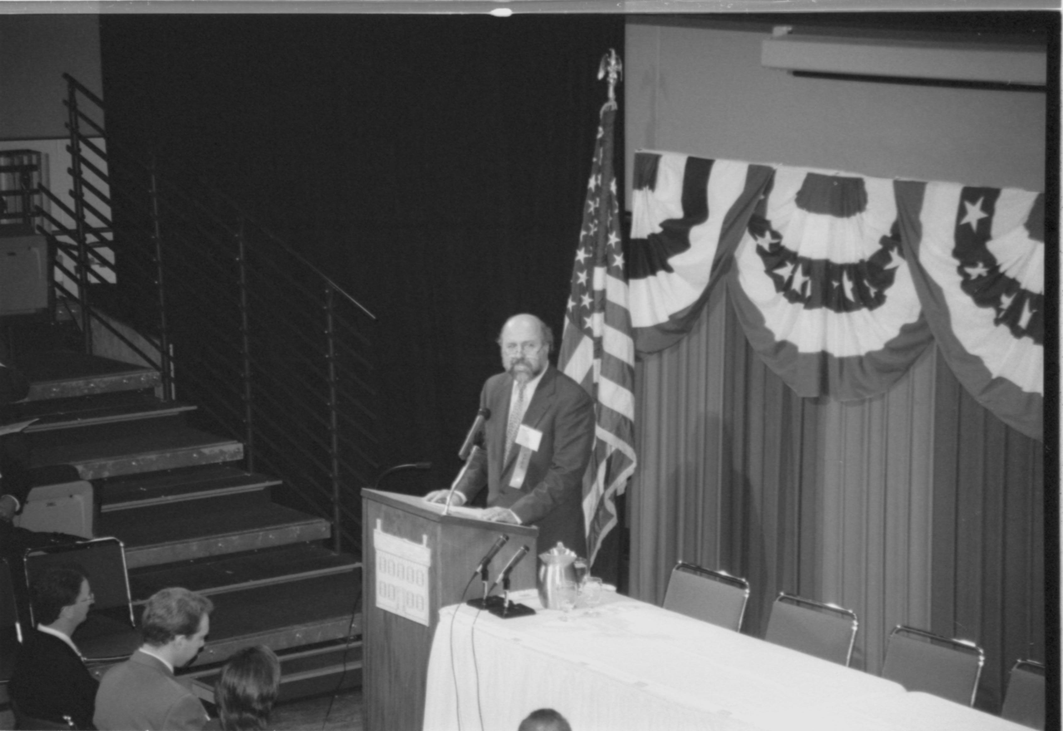 Male (balding) speaking at podium.  1999-16; 20 Colloquium, 1999