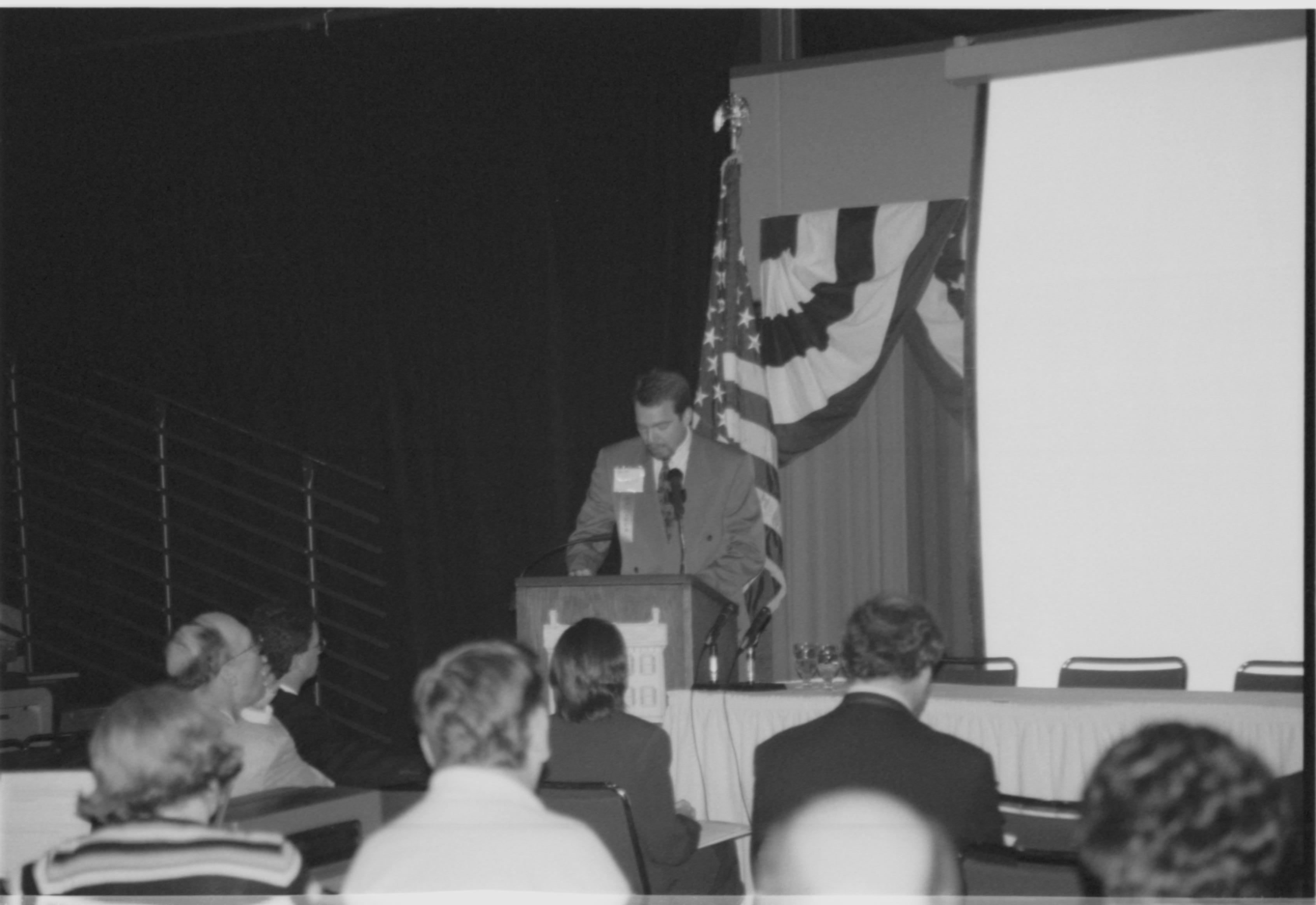 Man speaking at podium, looking down at notes.  1999-16; 24 Colloquium, 1999