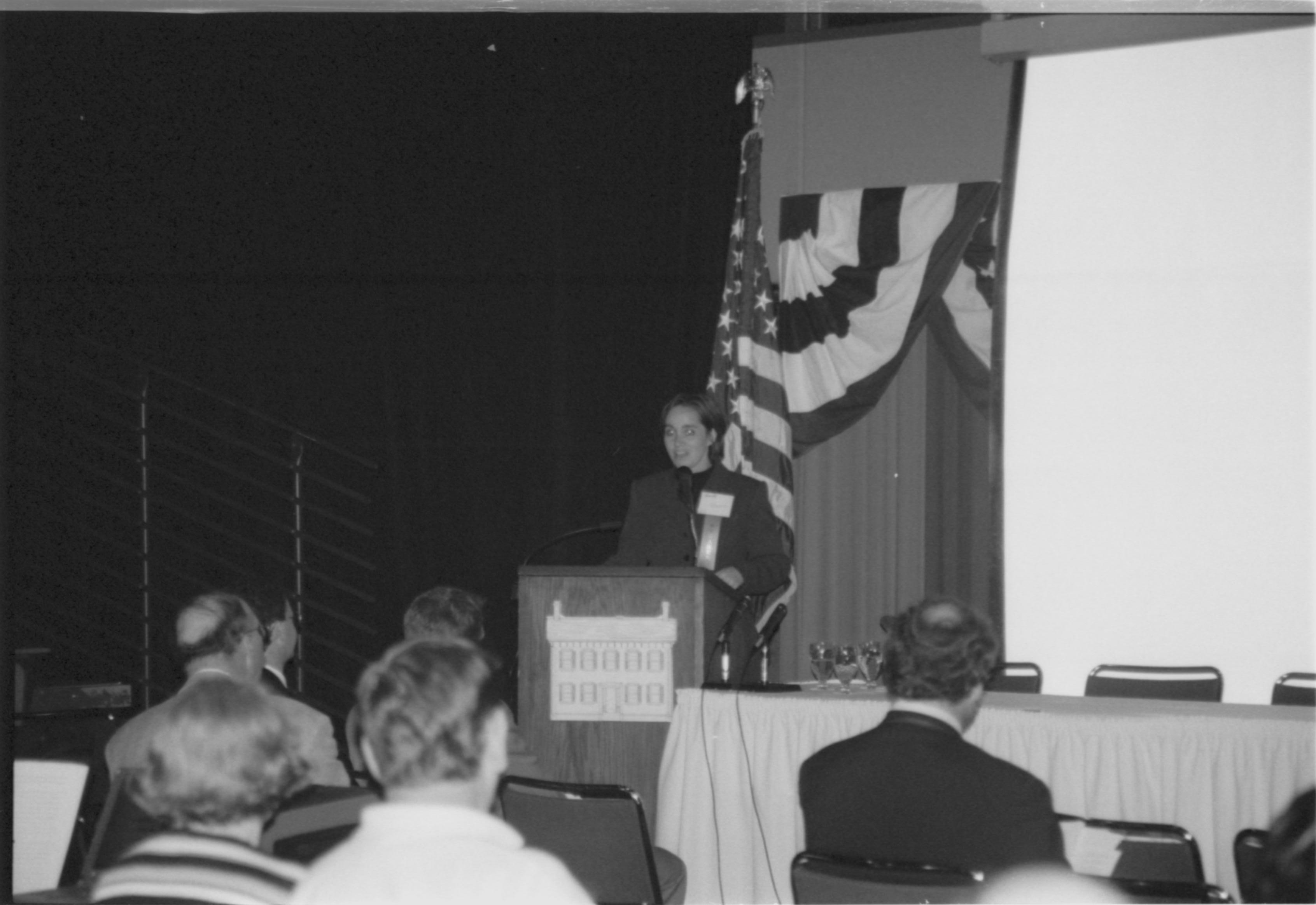 Lady speaking at podium. 1999-16; 26 Colloquium, 1999