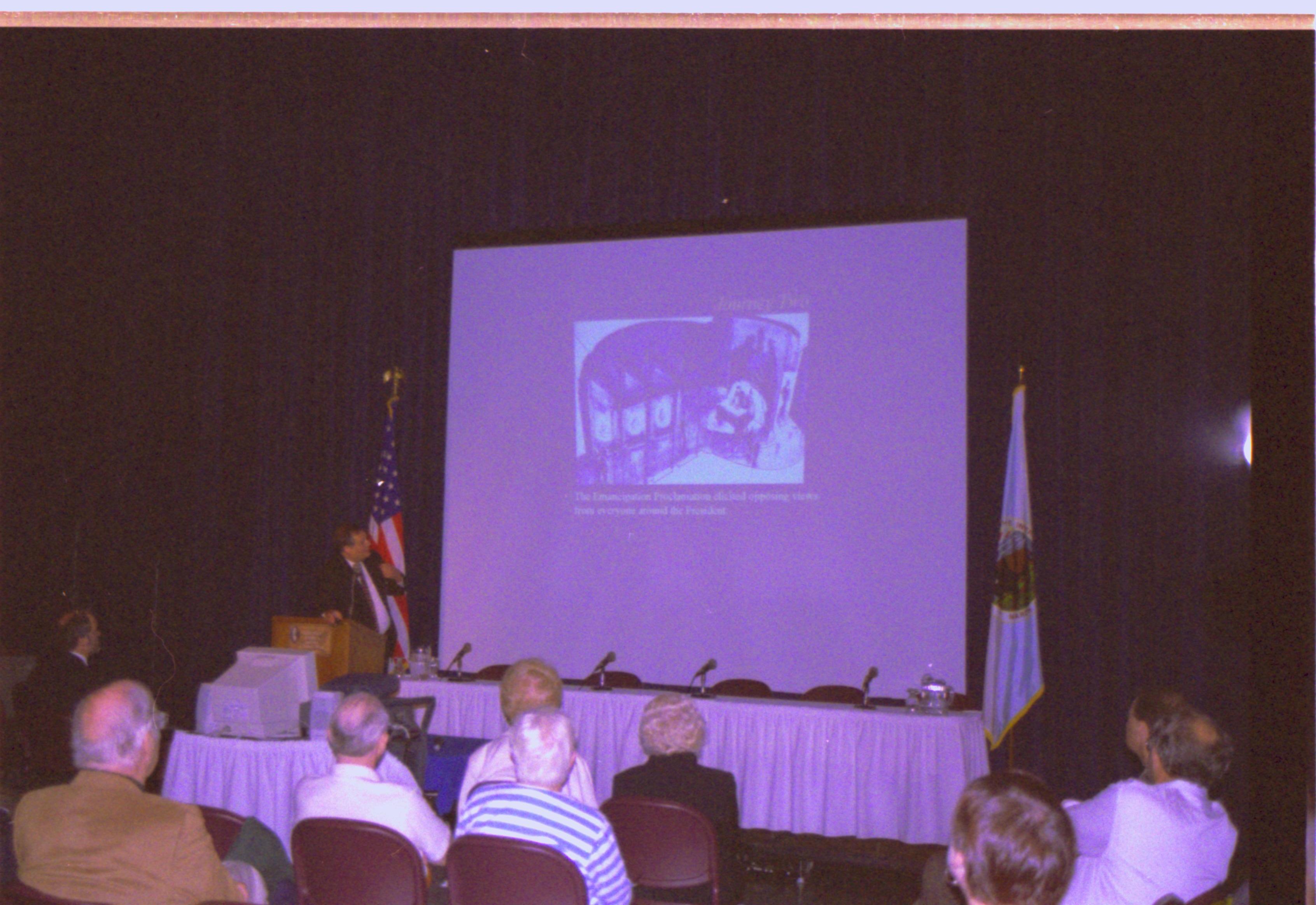 Speaker showing slides on screen. Colloquium, 2001
