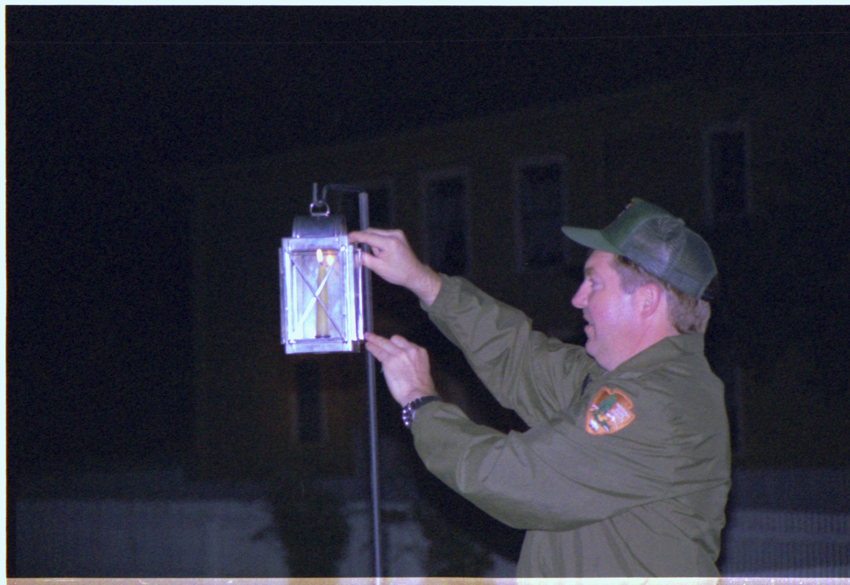 Man closing lantern. Candle lighting