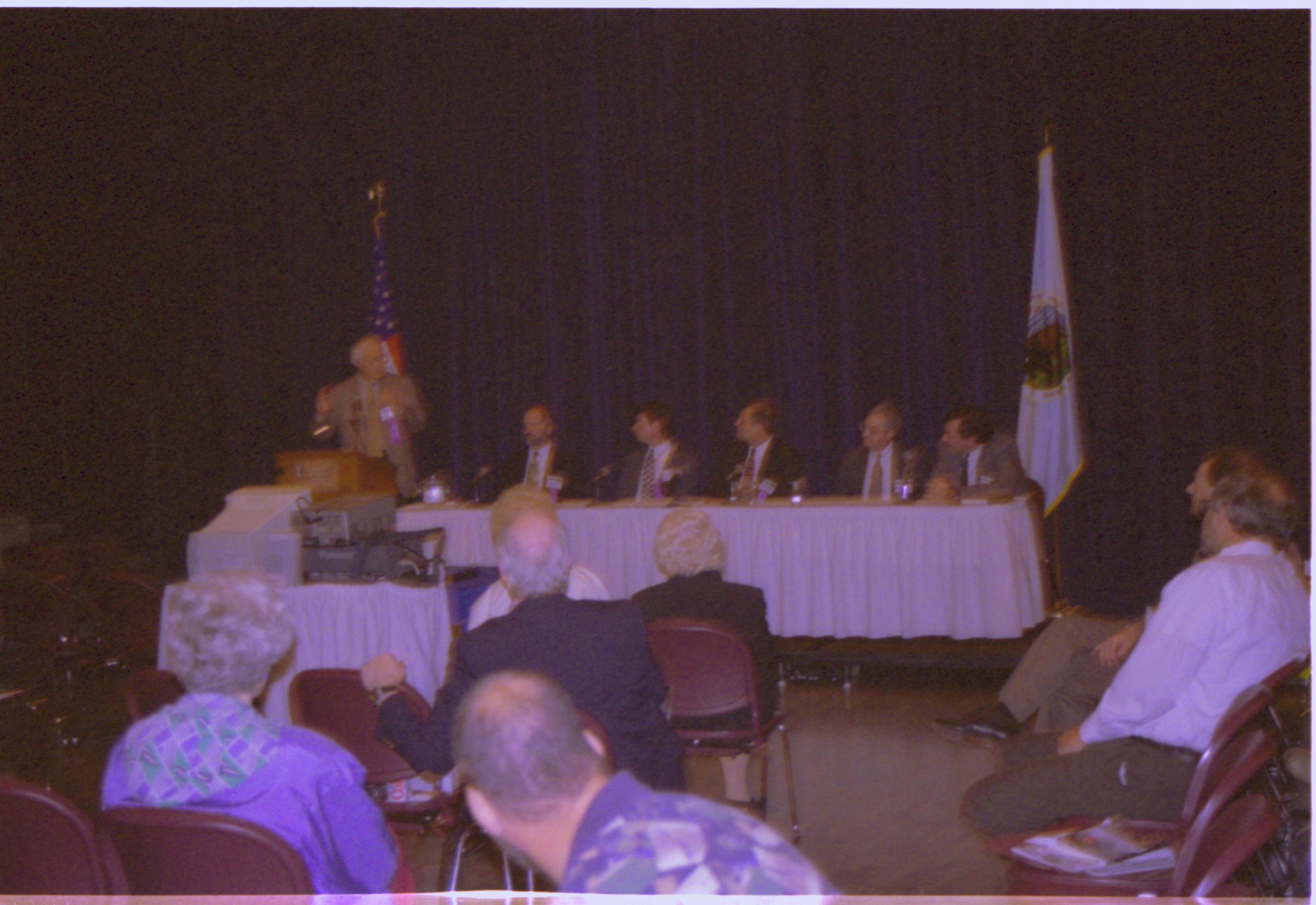 Speakers sitting at table on dias. Colloquium, 2001