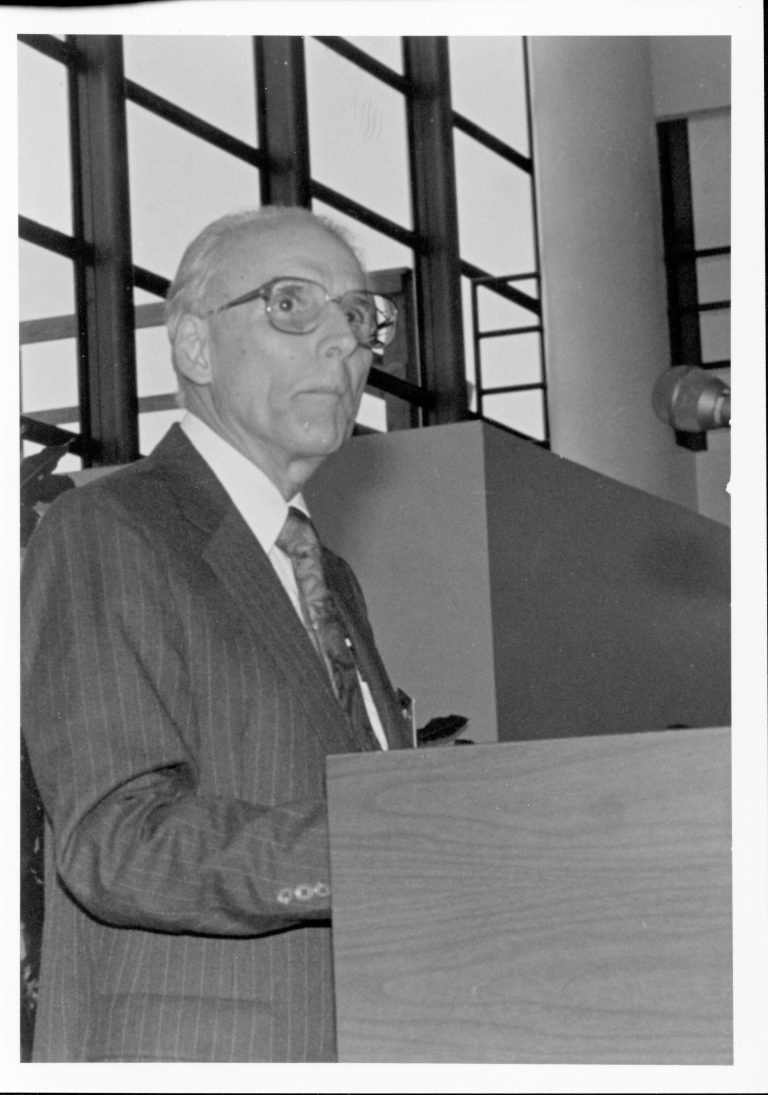 Man standing at podium. Lincoln, Colloquium