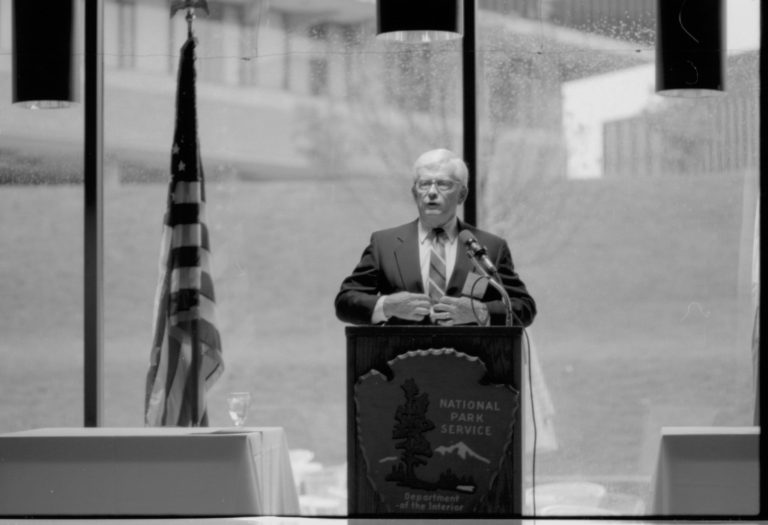 Man at NPS podium gesturing Colloquium, 1991 Lincoln, Colloquium