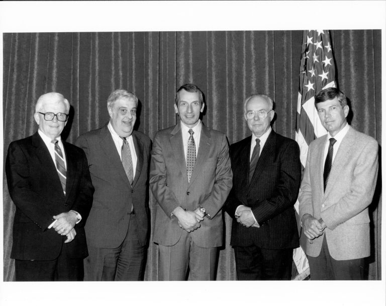 Five men posing for picture by American flag. Lincoln, Colloquium