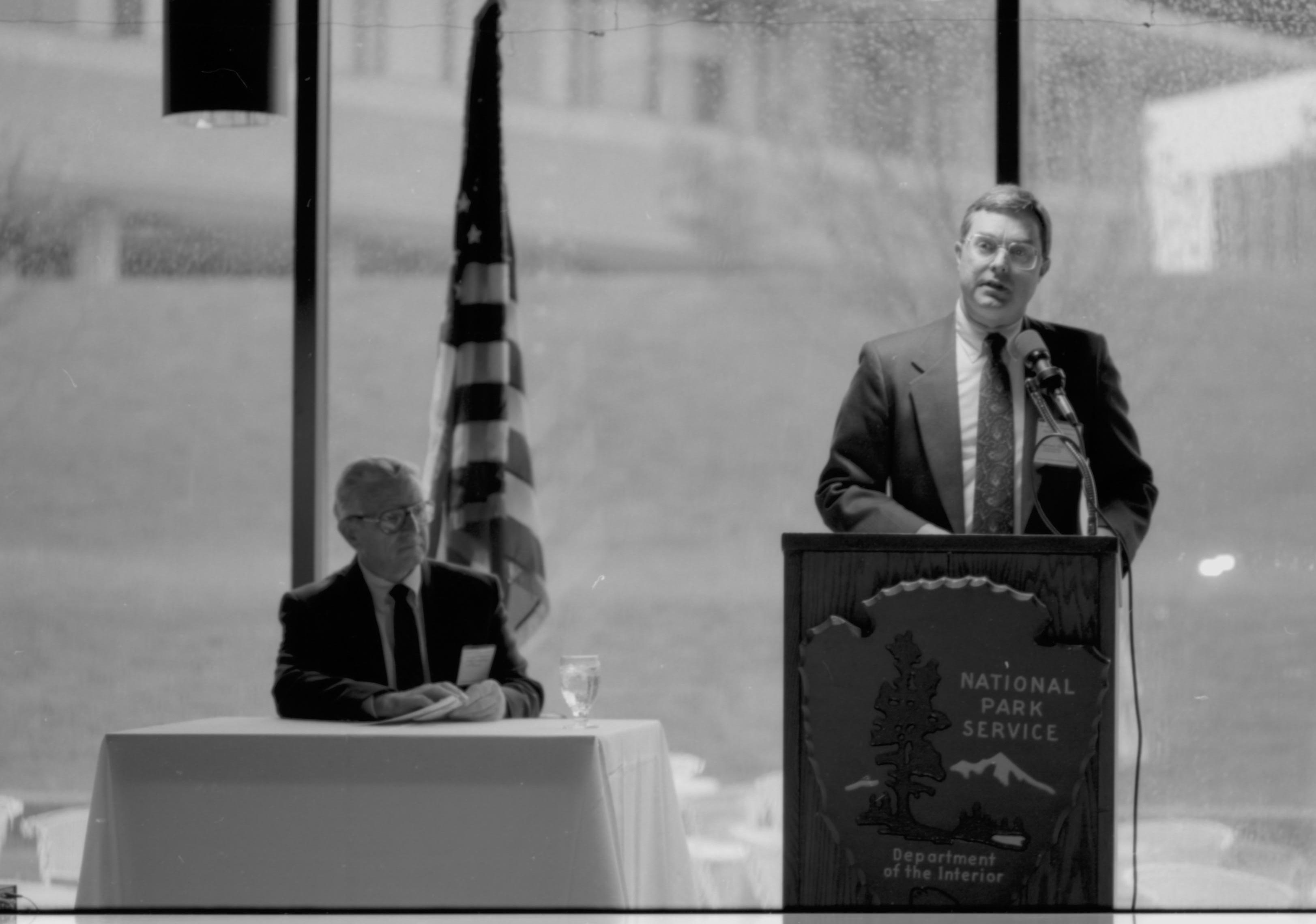 One man seated, one standing speaking. Colloquium, 1991 Lincoln, Colloquium