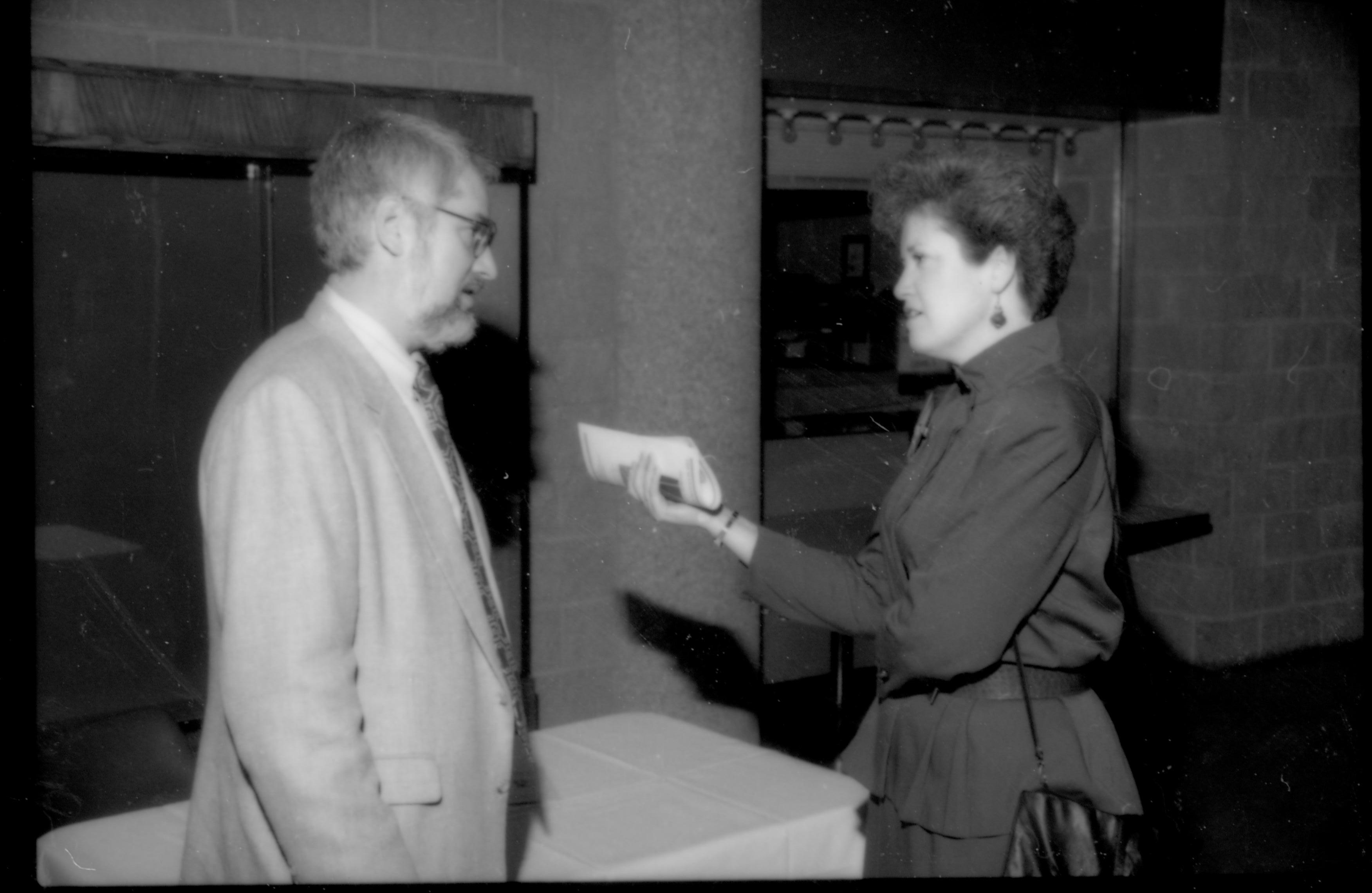 Lady, holding booklet,  talking to a man 1992 Lincoln Colloquium; Outside #72 Lincoln, Colloquium