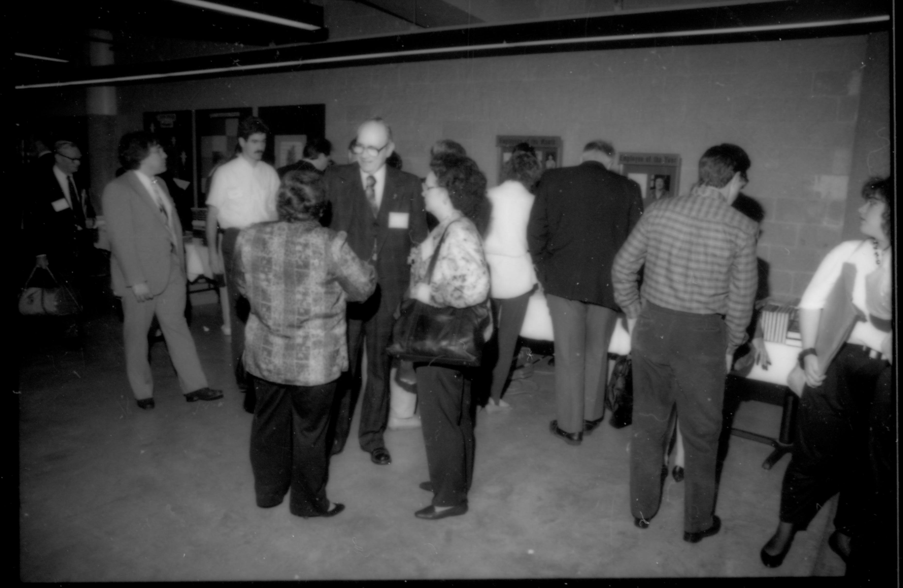 People standing around talking, others at book tables. 1992 Lincoln Colloquium; Outside #72 Lincoln, Colloquium