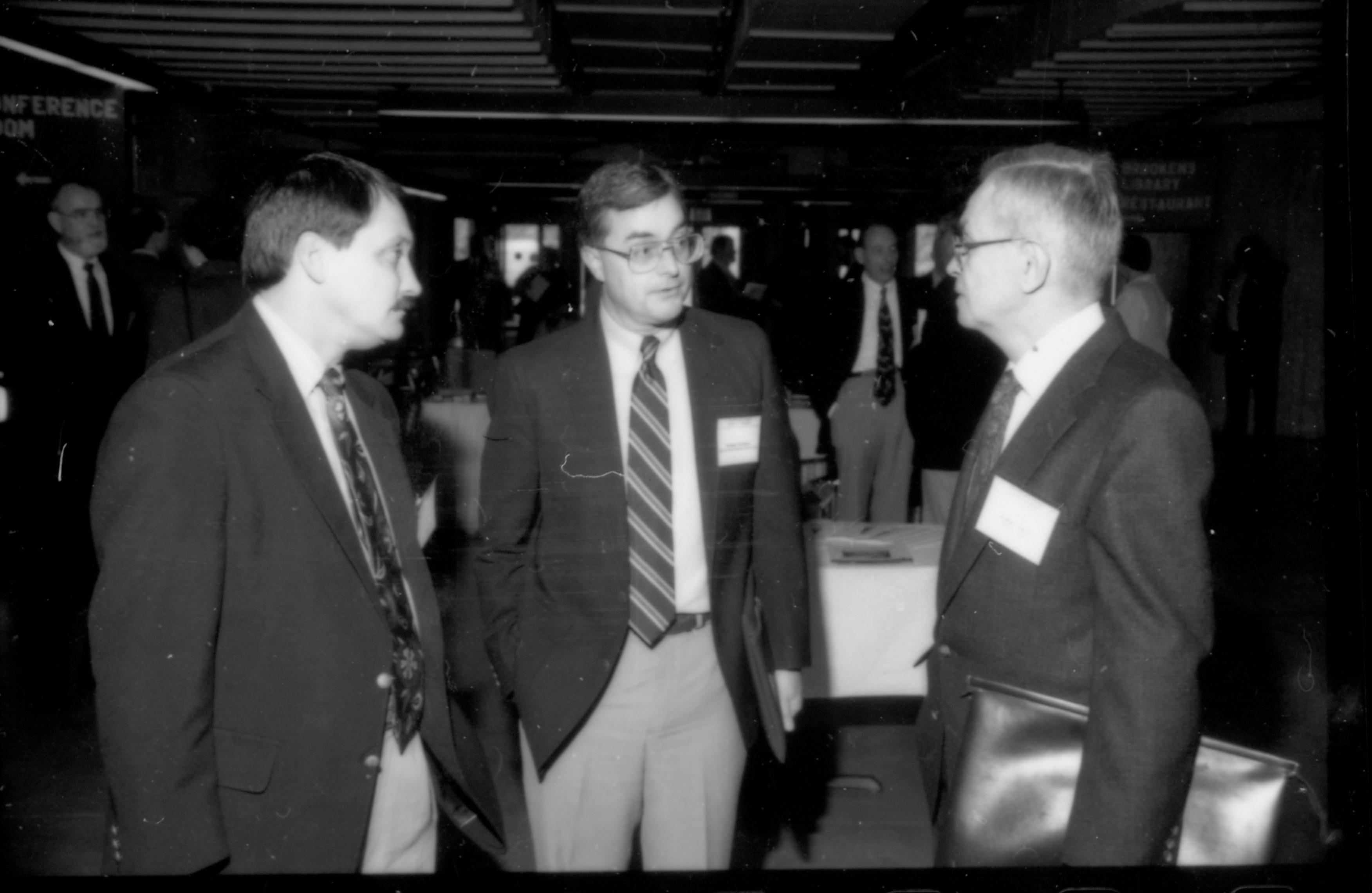 Three men in dark coats talking to one another. 1992 Lincoln Colloquium; Outside #72 Lincoln, Colloquium