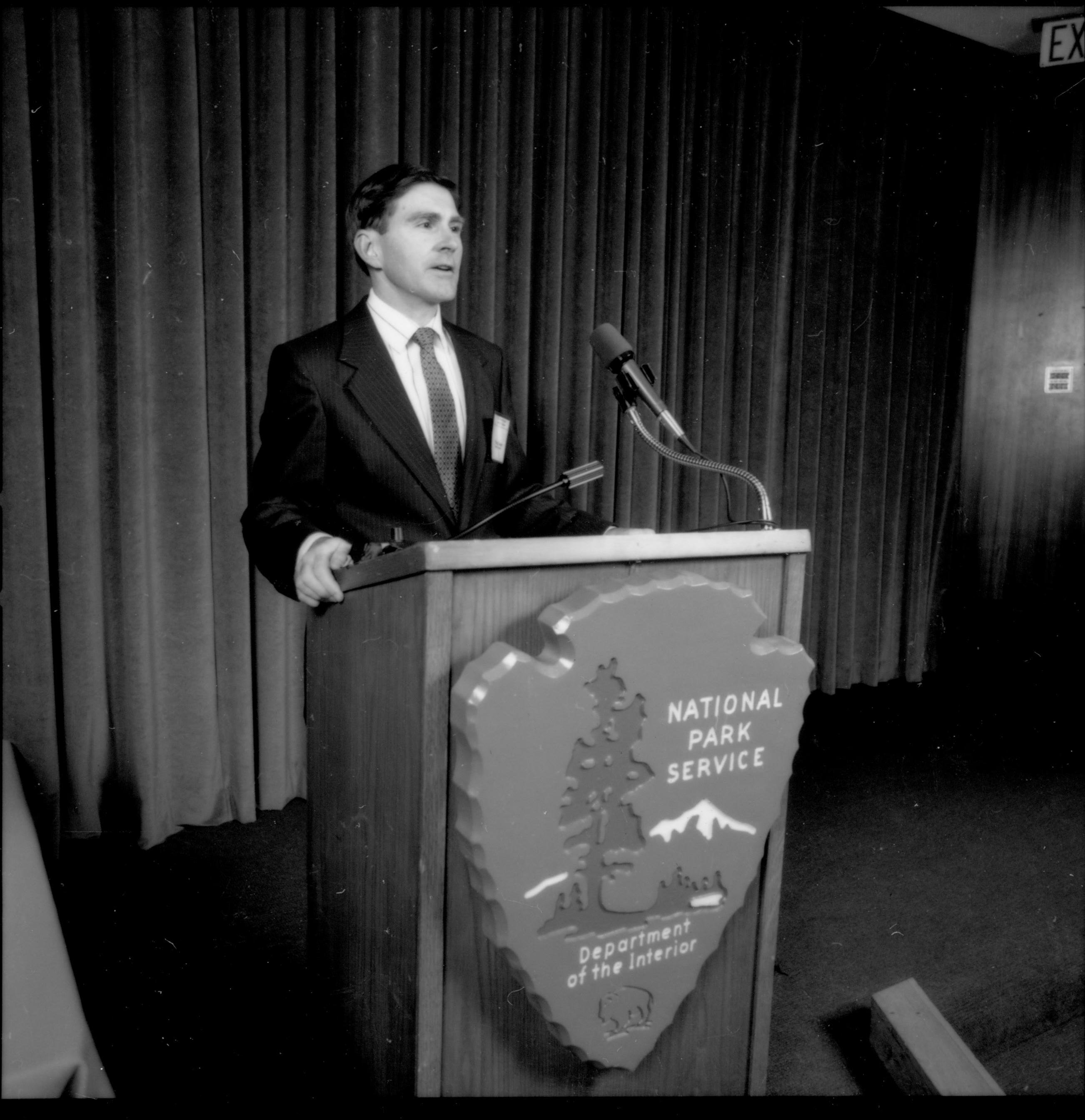 Man in dark suit at podium. 1992 Lincoln Colloquium; Outside #69 Lincoln, Colloquium