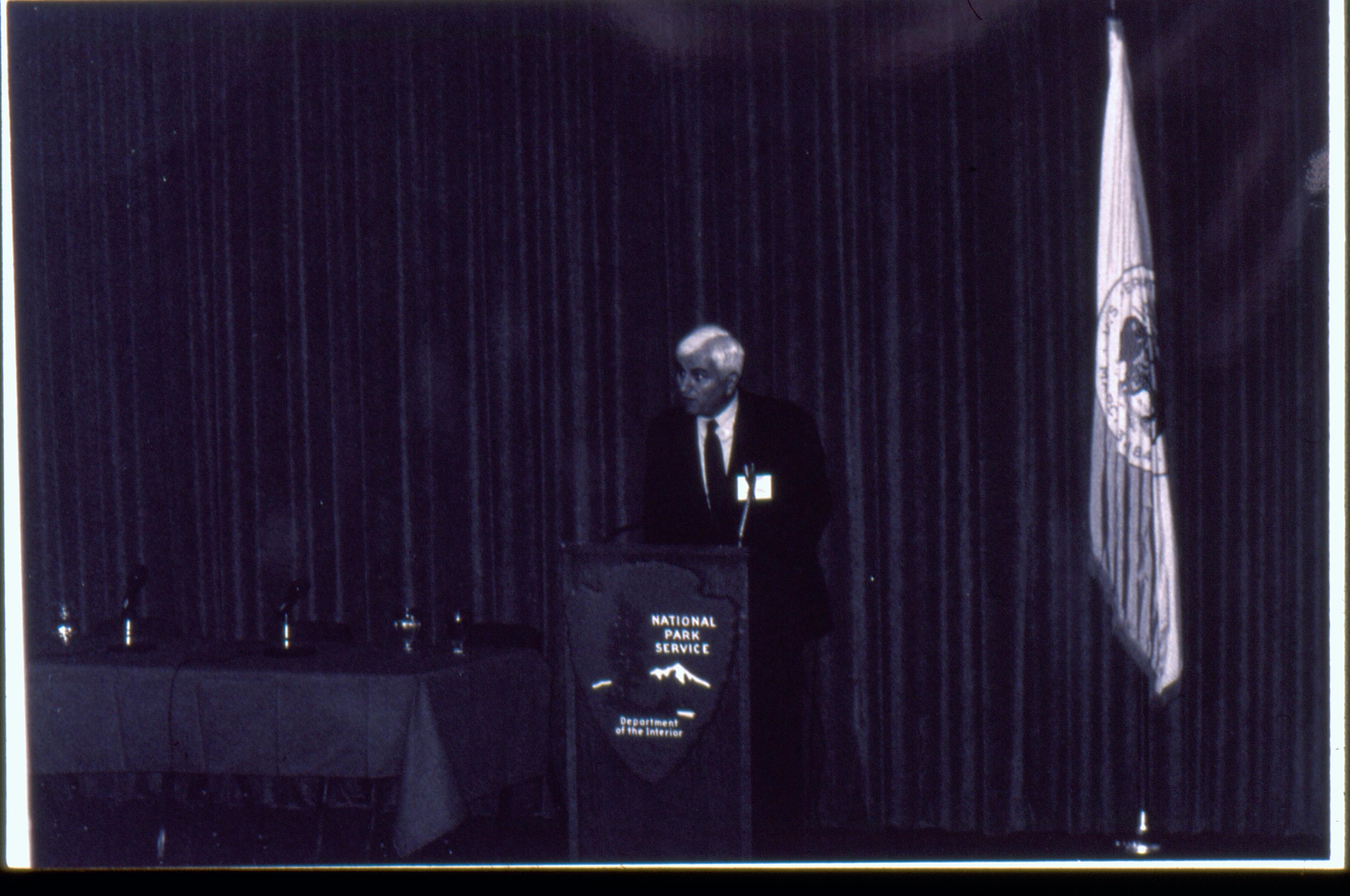 Man at podium with curtain behind him.(Dark picture). 1992 Lincoln Colloquium Lincoln, Colloquium