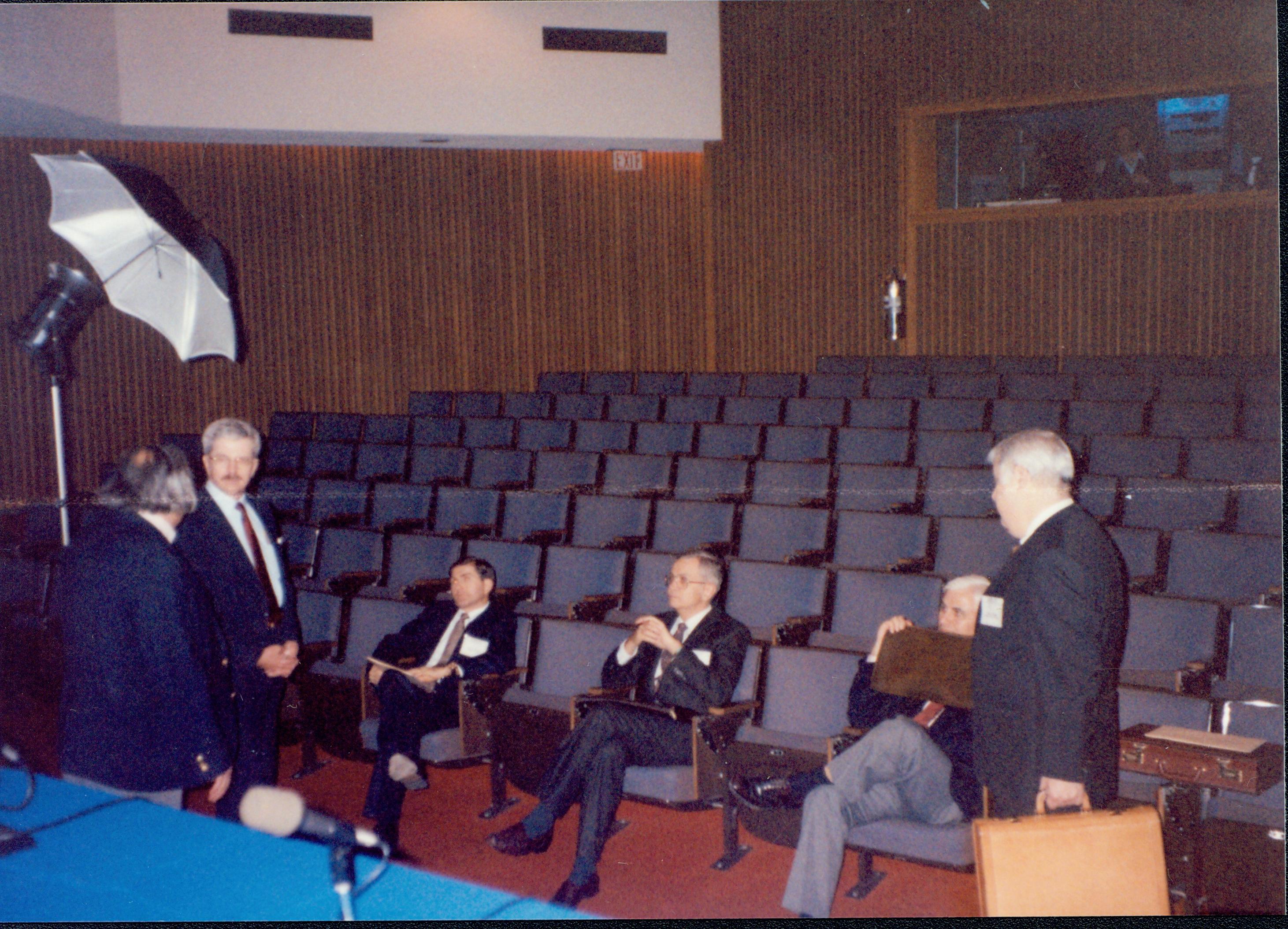 Three men seated, three standing in empty auditorum. 1992 Lincoln Colloquium Lincoln, Colloquium