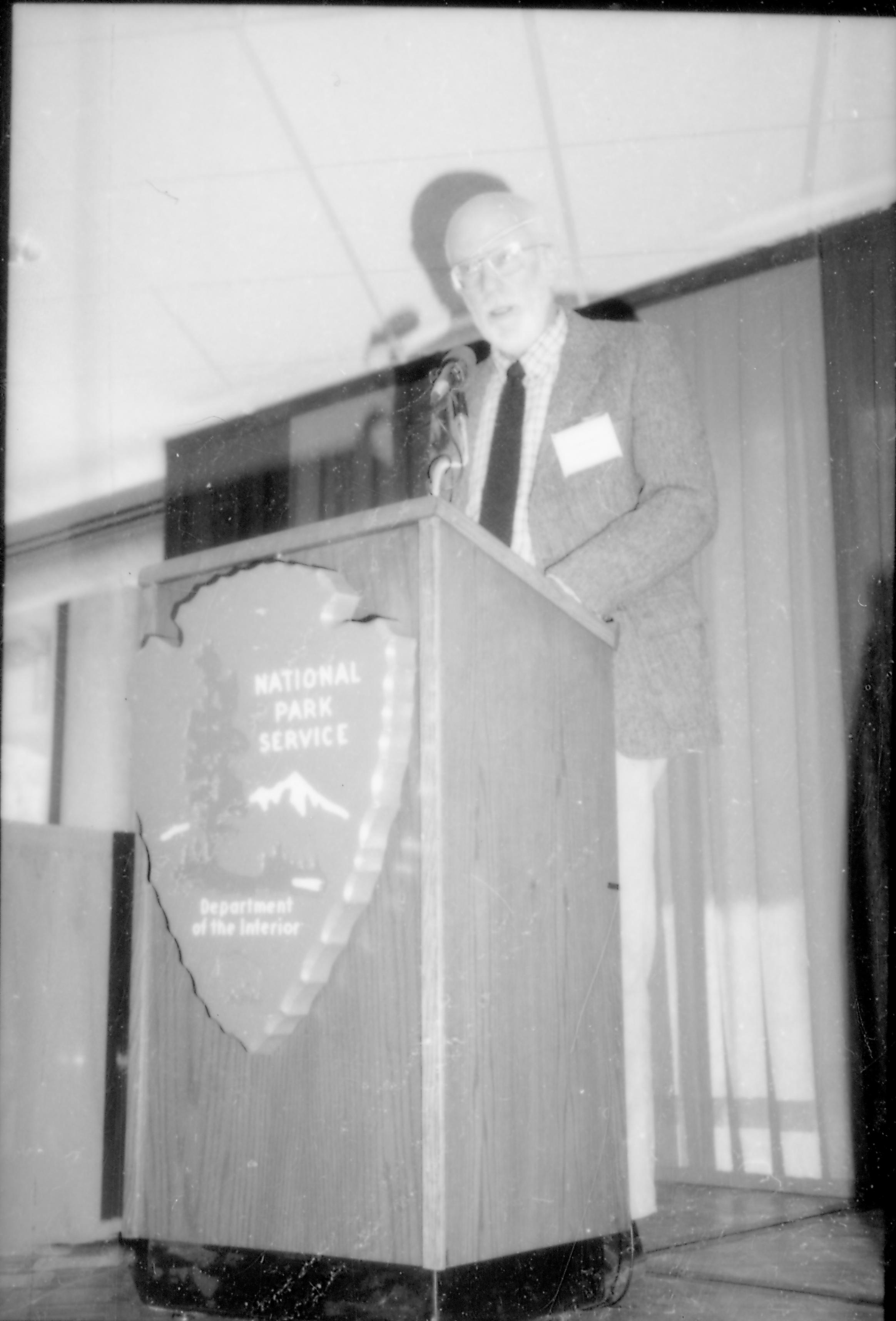 Man speaking at podium. 8th Annual Lincoln Colloquium; A Lincoln, Colloquium